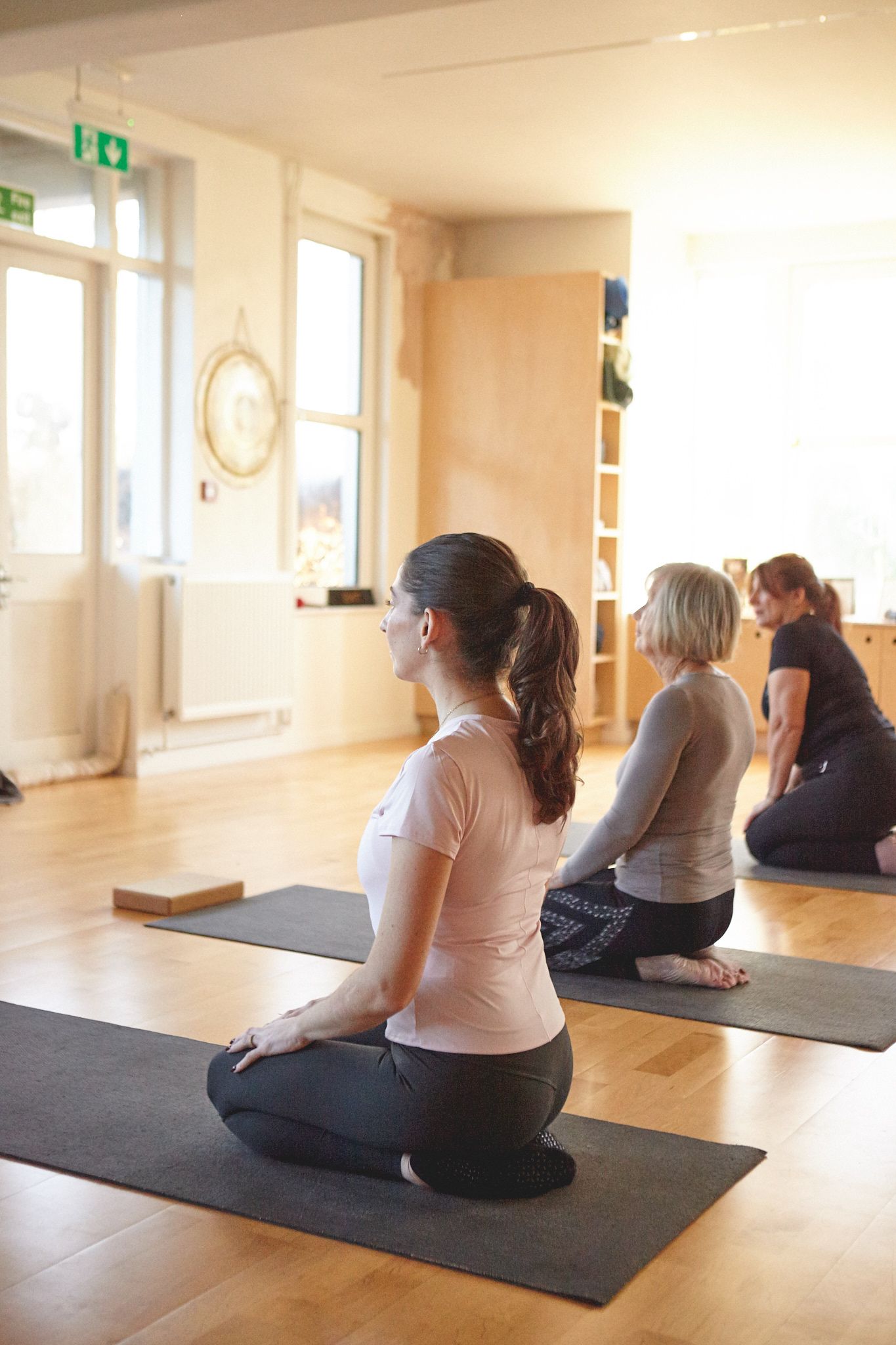 Women sitting on mats during a Pilates class near Woodbridge for a brand photoshoot
