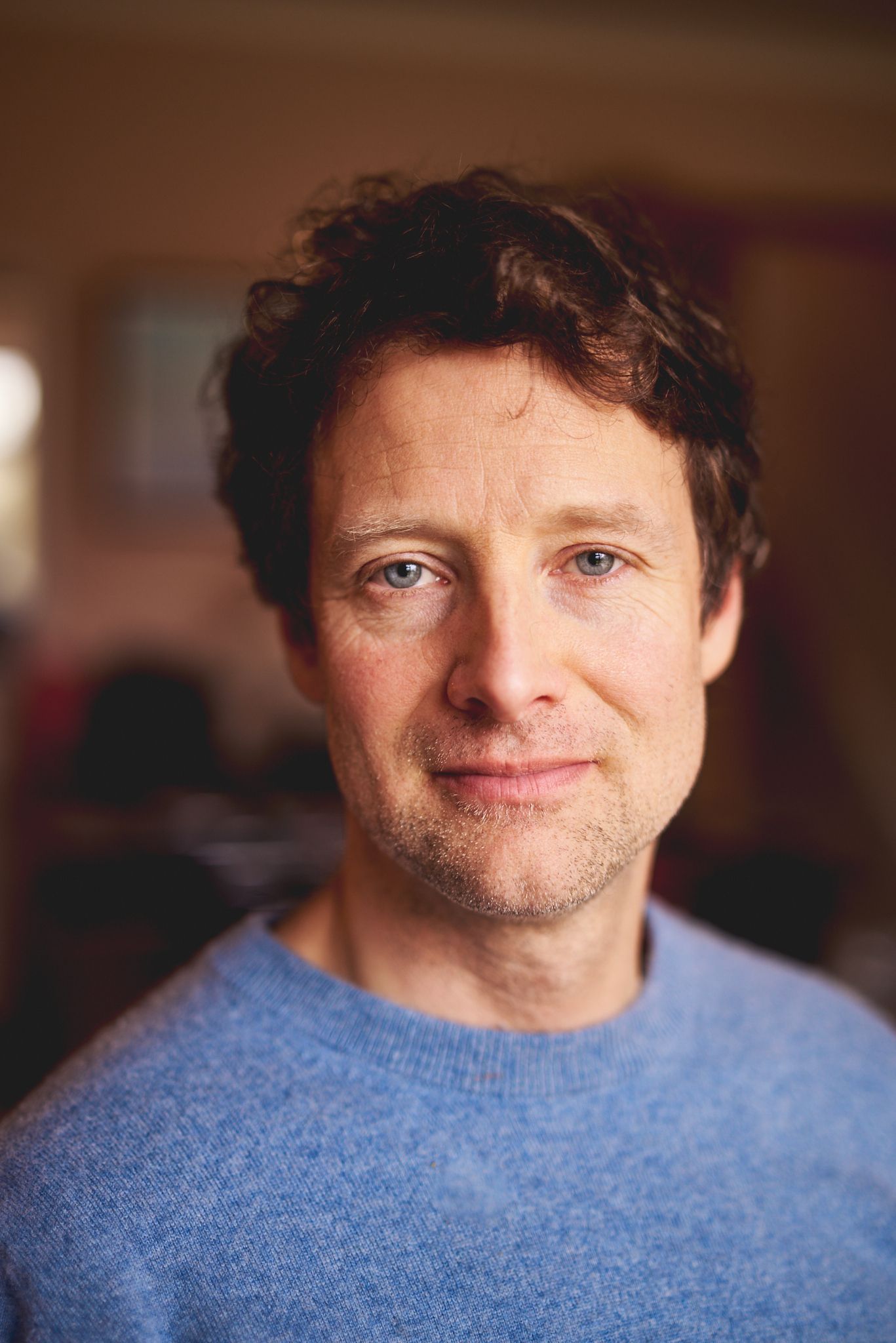 Creative branding portrait of a small business owner in a blue jumper