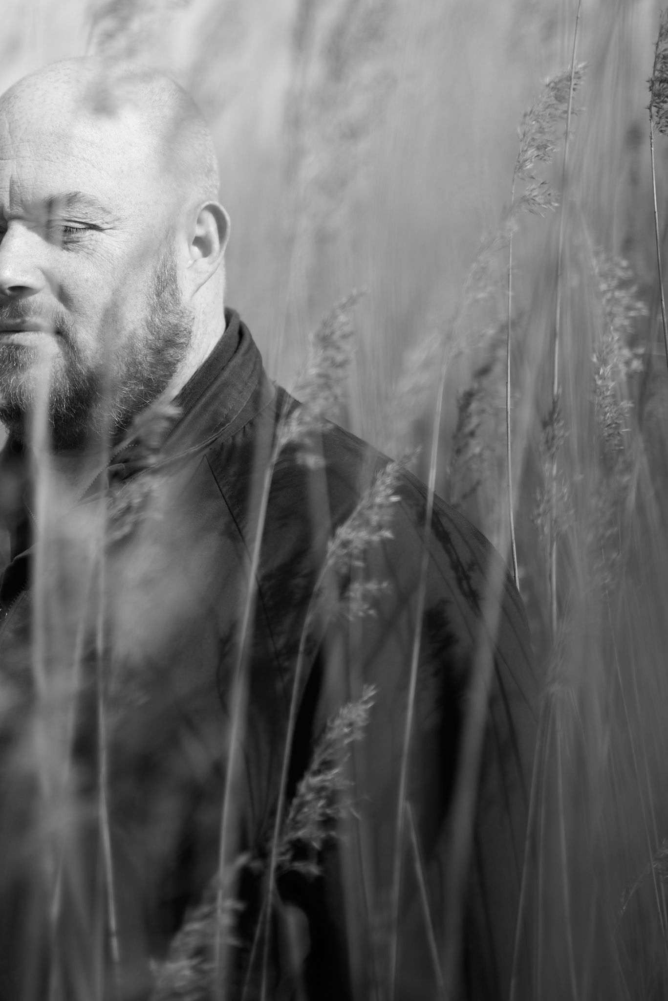 Composer standing among reeds in Snape, Suffolk, photographed for a natural portrait session