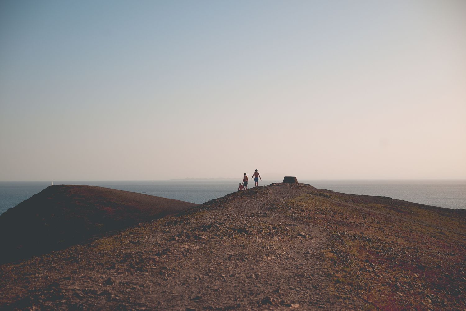 People in distance walking on headland in evening light Lanzarote by Cat Heygate Photo