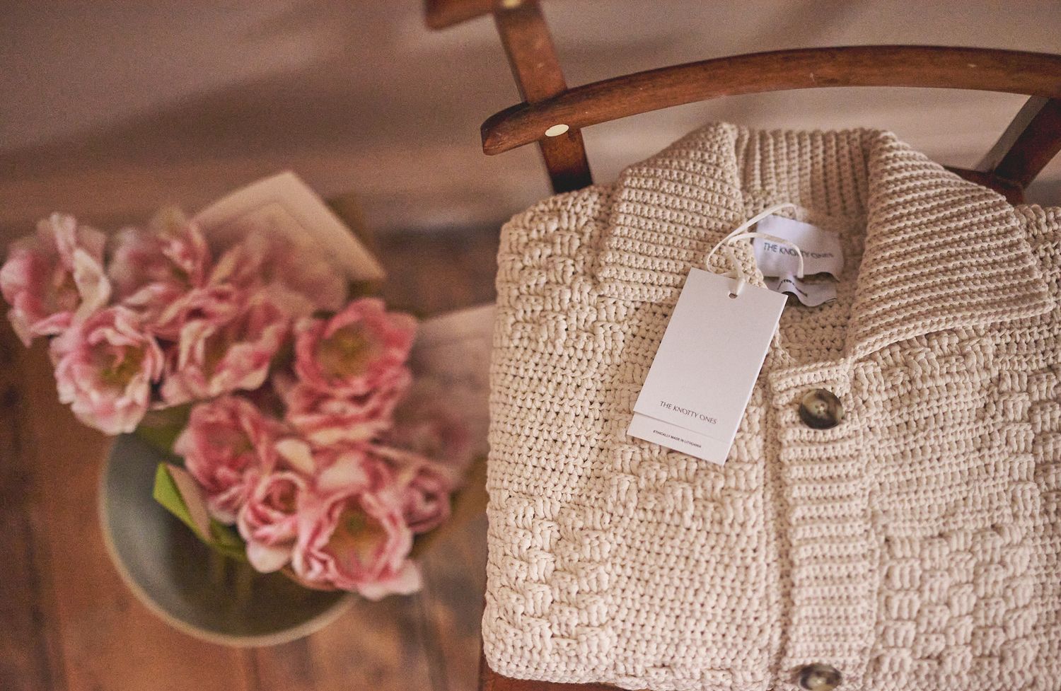 Cotton cardigan on chair next to tulips natural light for small clothes shop Woodbridge by Cat Heygate Photo