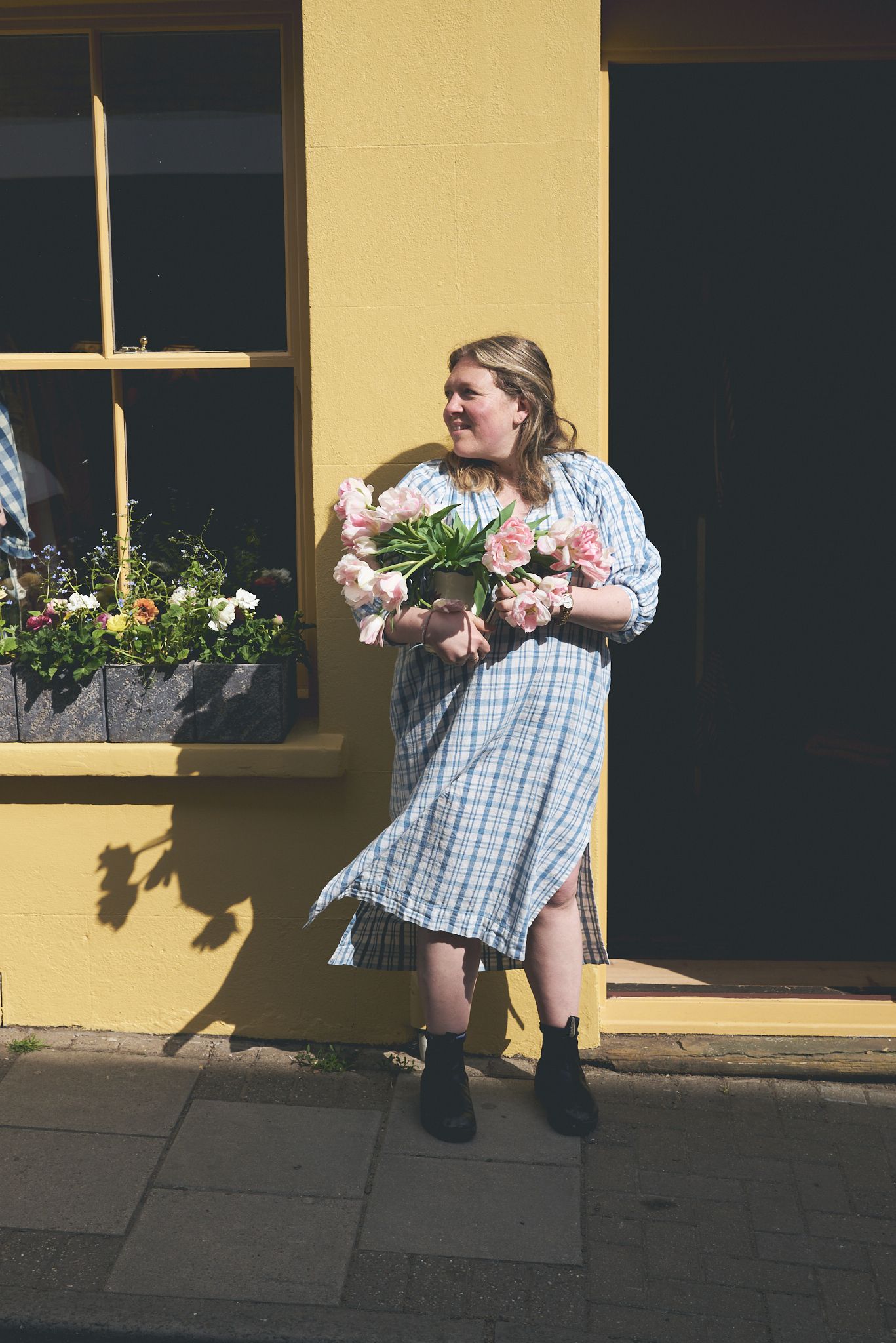 Entrepreneur holding tulips outside her independent clothing shop in Woodbridge during a brand photoshoot