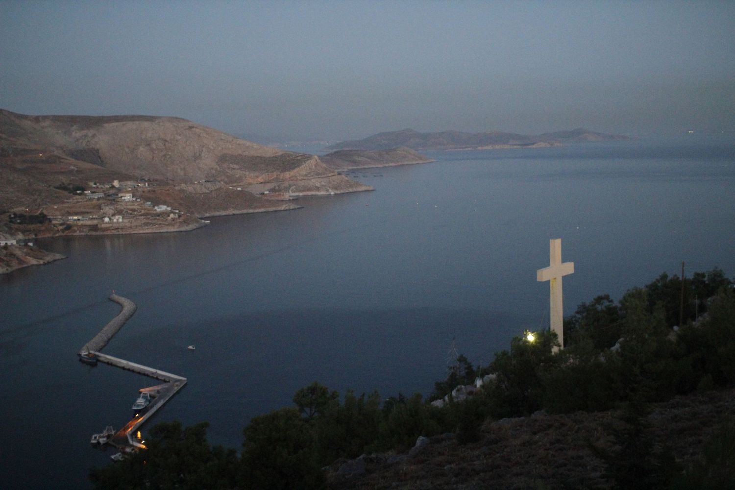 A cross on a hillside at dusk in Greece by Cat Heygate Photo