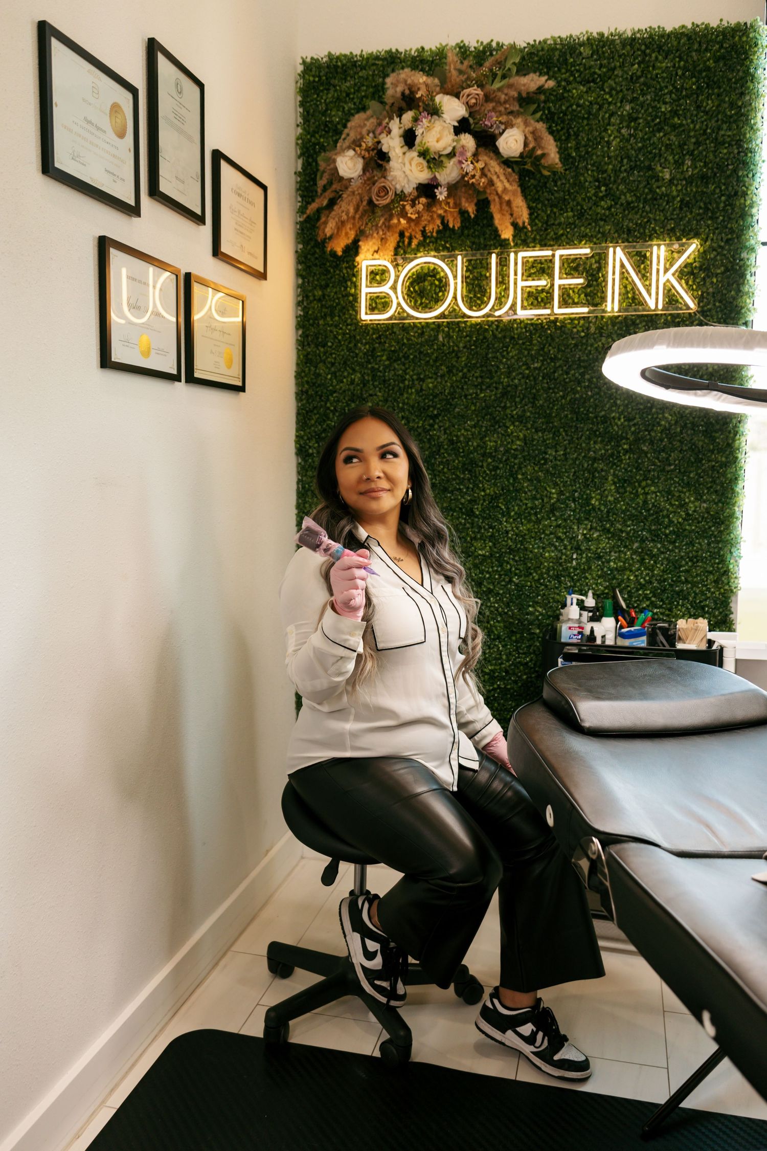 Female beauty artist posing with a brush at her Boujee Ink permanent makeup studio.