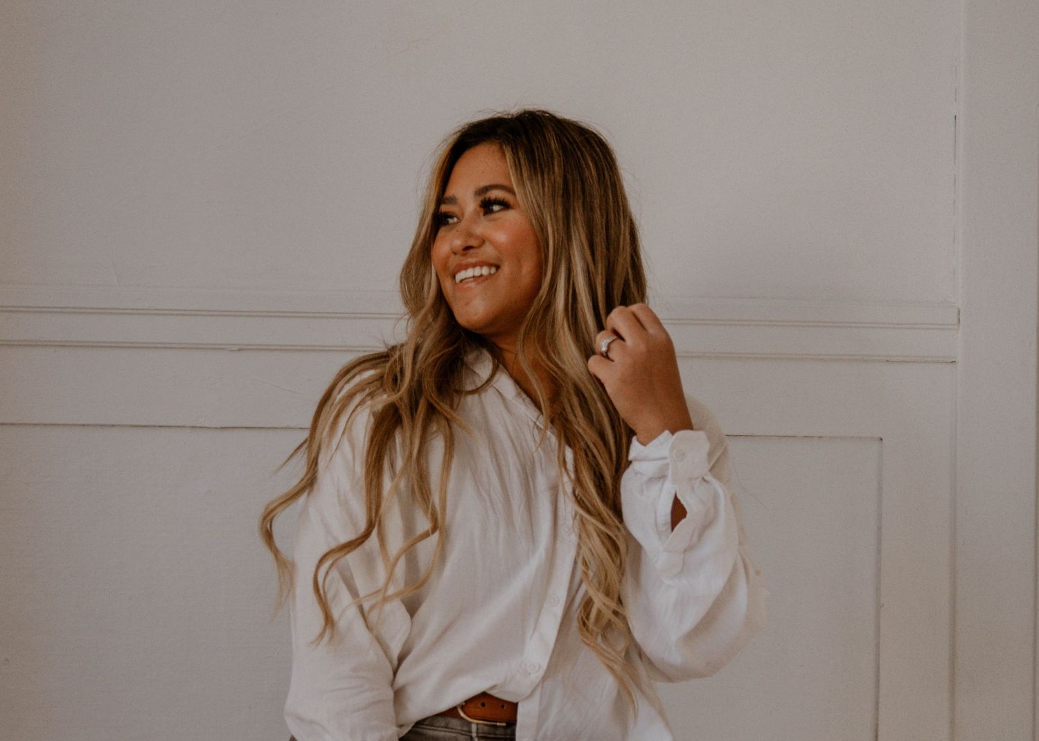 Woman photographer smiling looking to the left wearing a white shirt