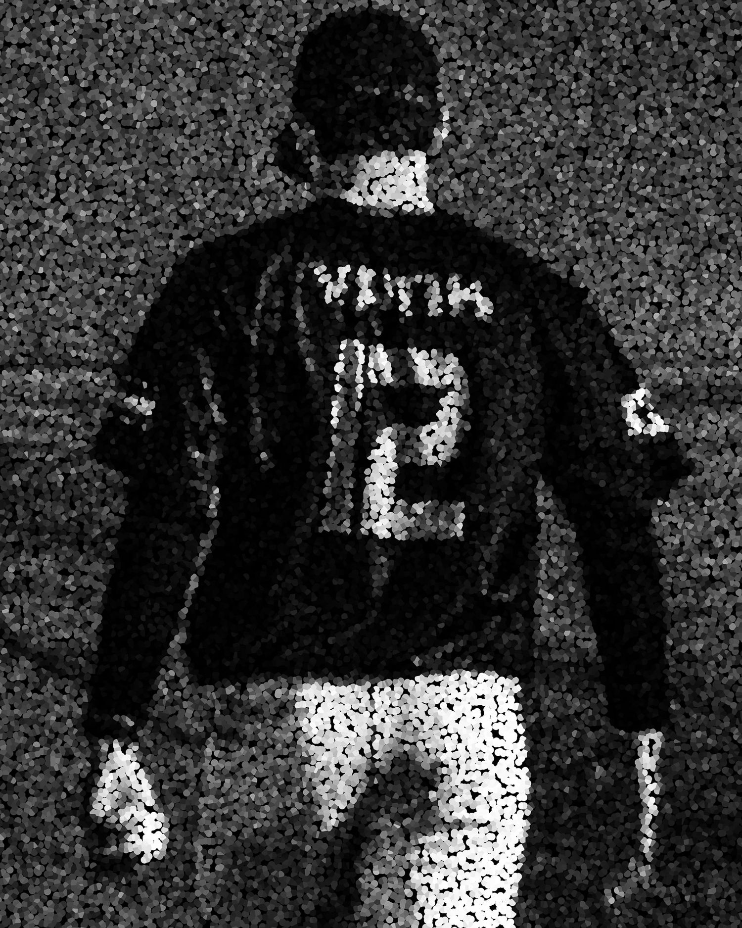 Grainy black and white photo of baseball player #12 walking away.