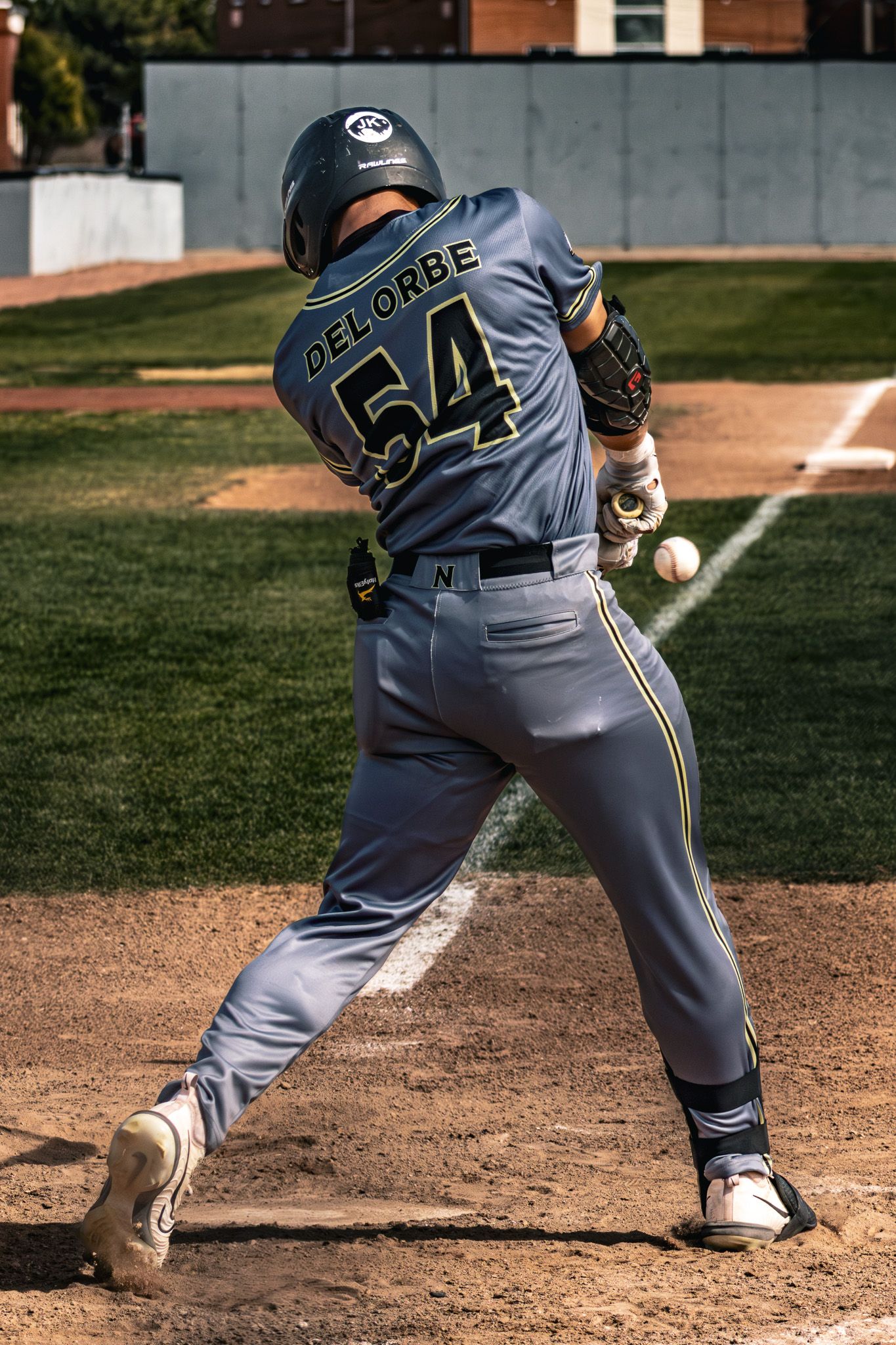 Baseball player Delorbe #54 makes contact with pitch during game.