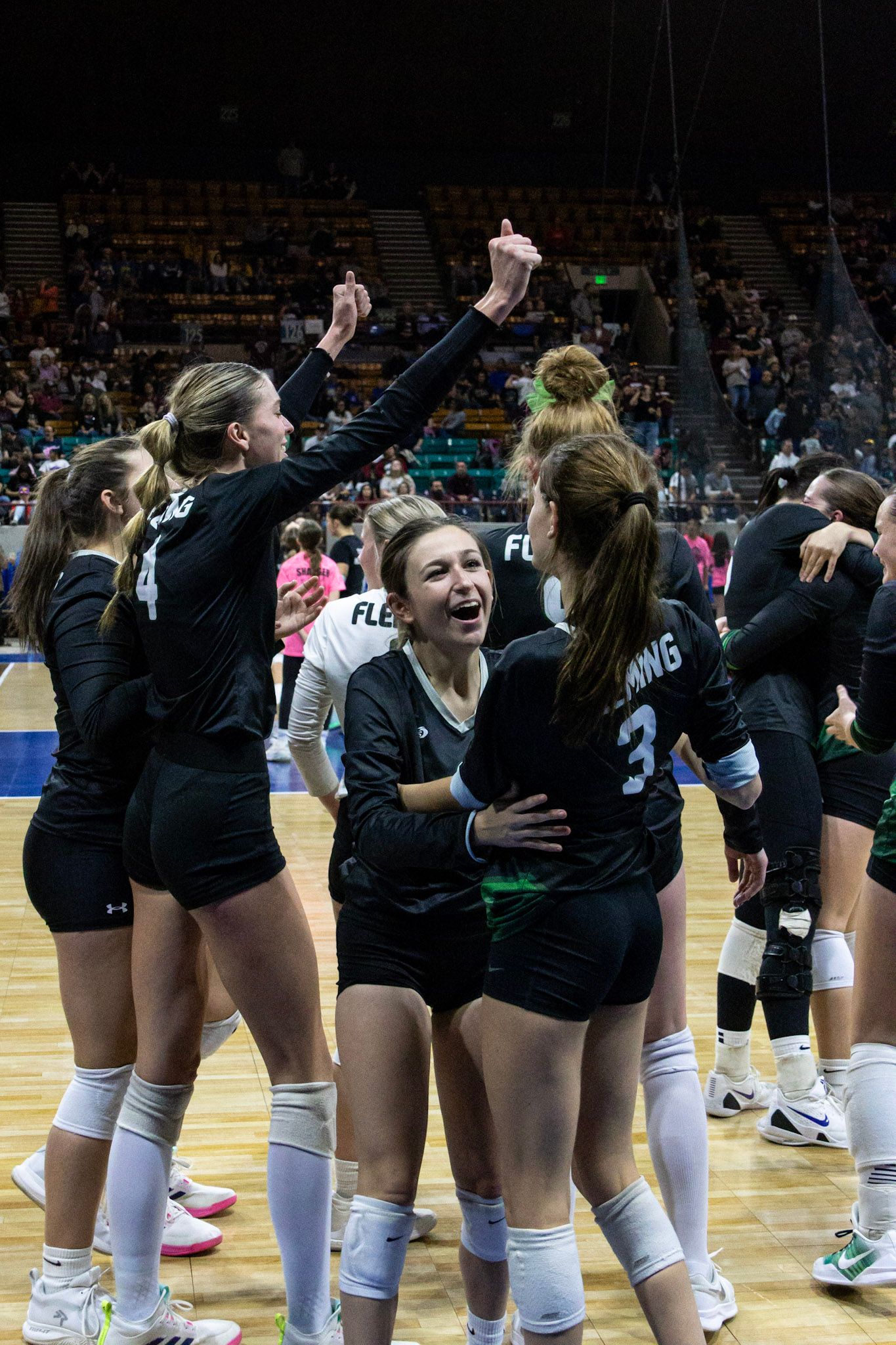 Fleming volleyball team celebrates victory together on court after tournament win.