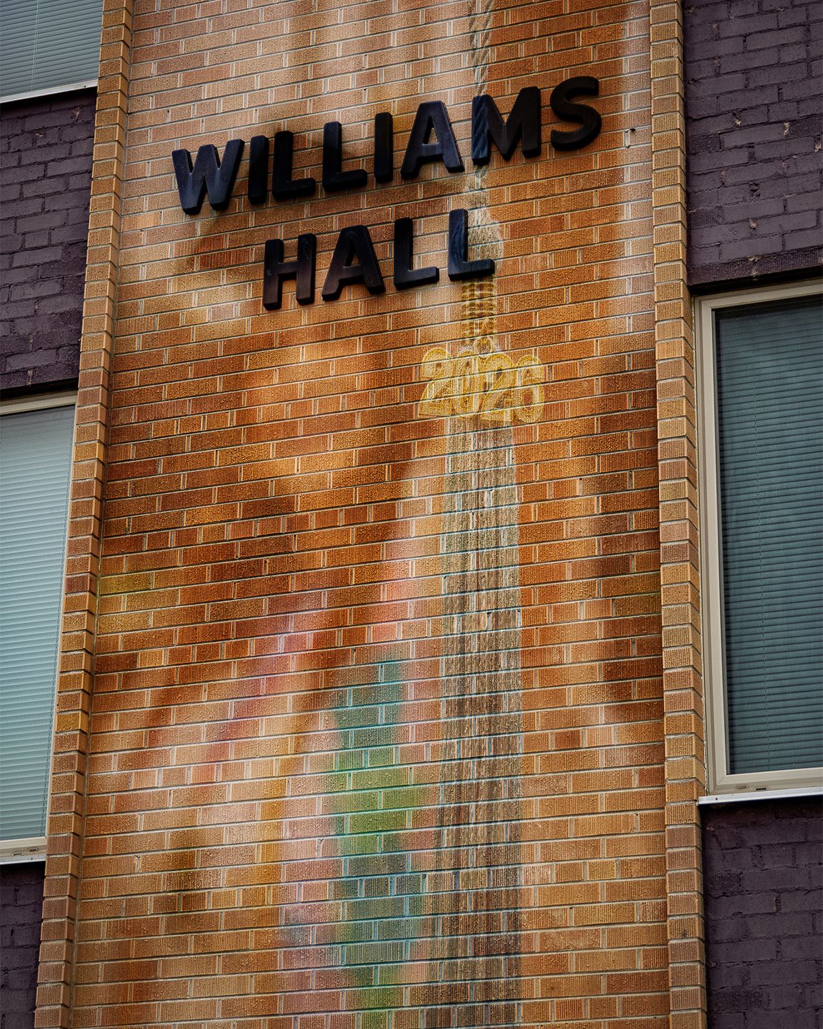 Williams Hall brick building exterior with 2026 graduation banner mural.