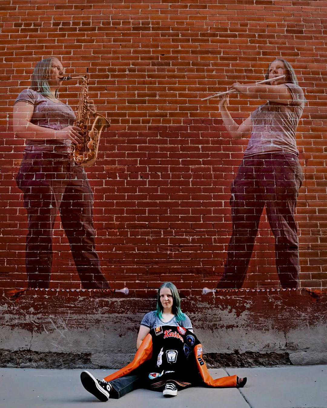 Creative senior portrait of a musician sitting before a brick wall mural featuring her playing saxophone and flute.
