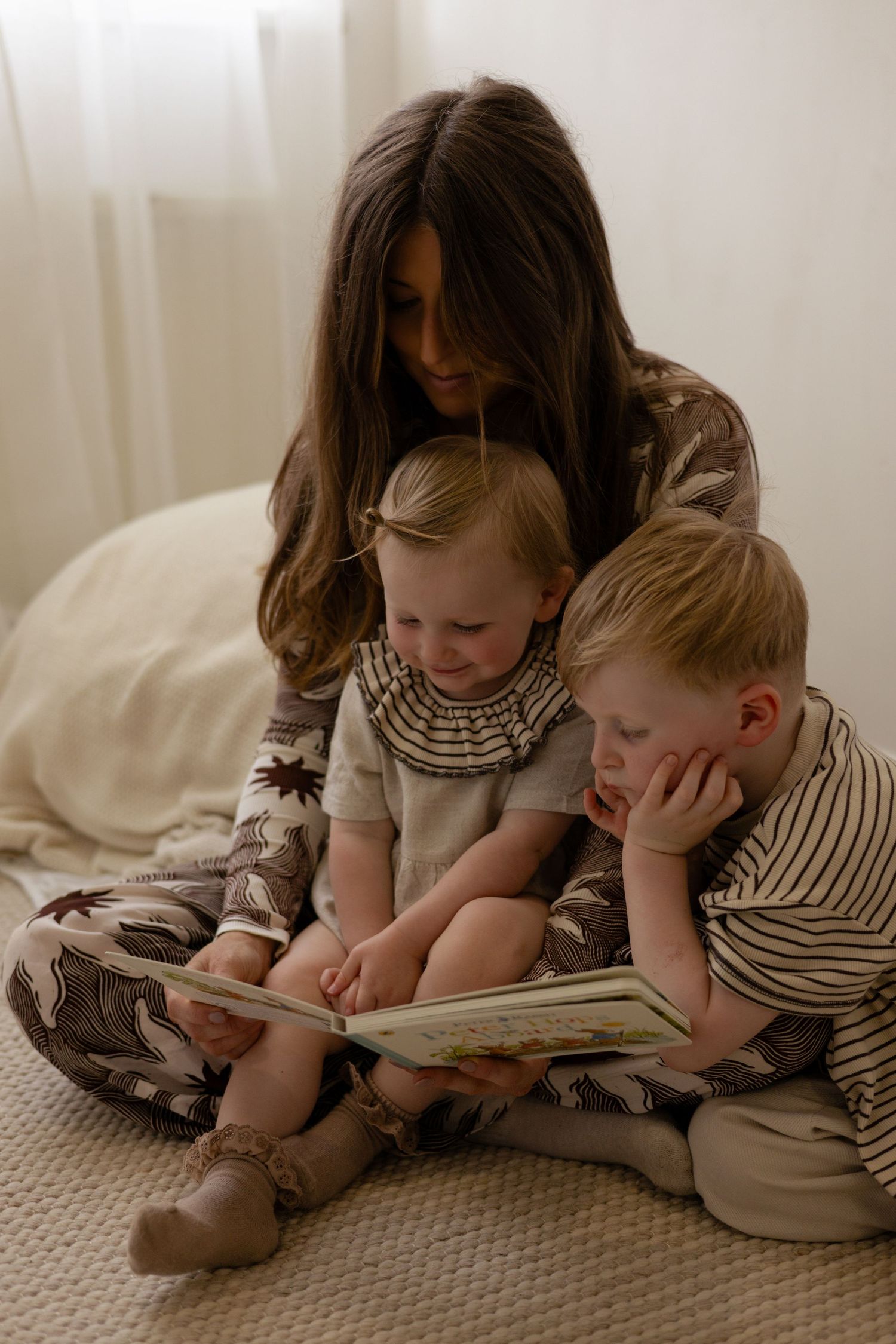 A mother and her children reading a book