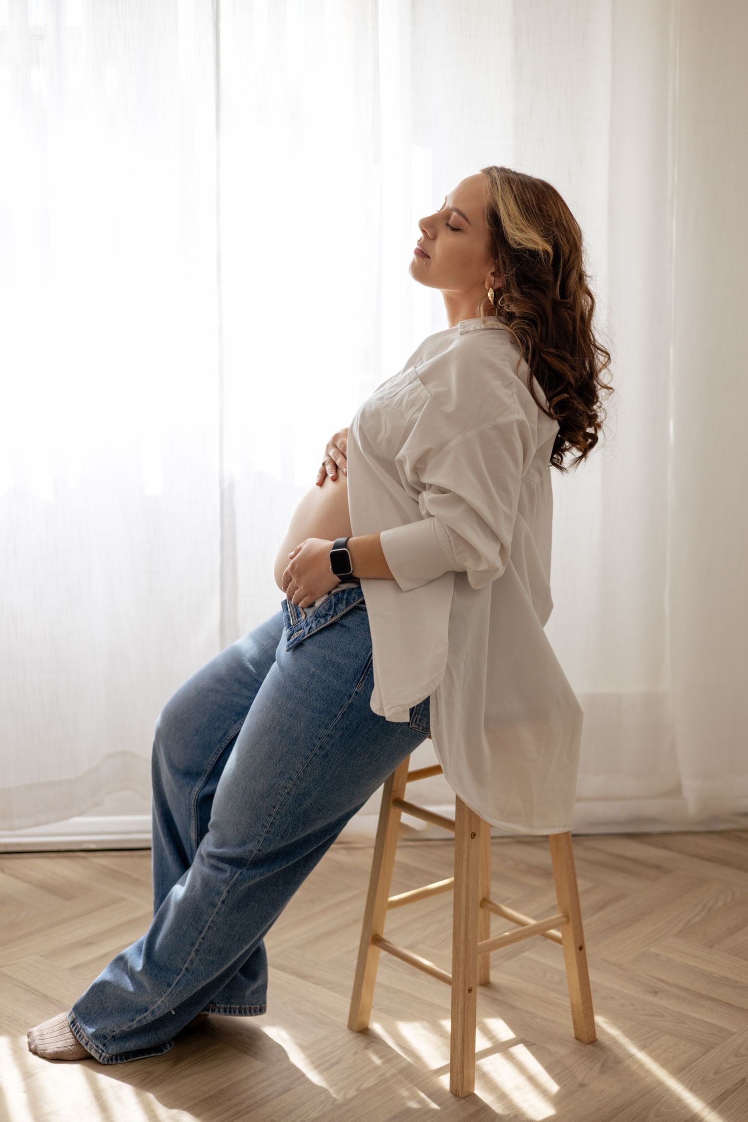 A pregnant mother embracing her beautiful baby bump as part of a maternity photoshoot