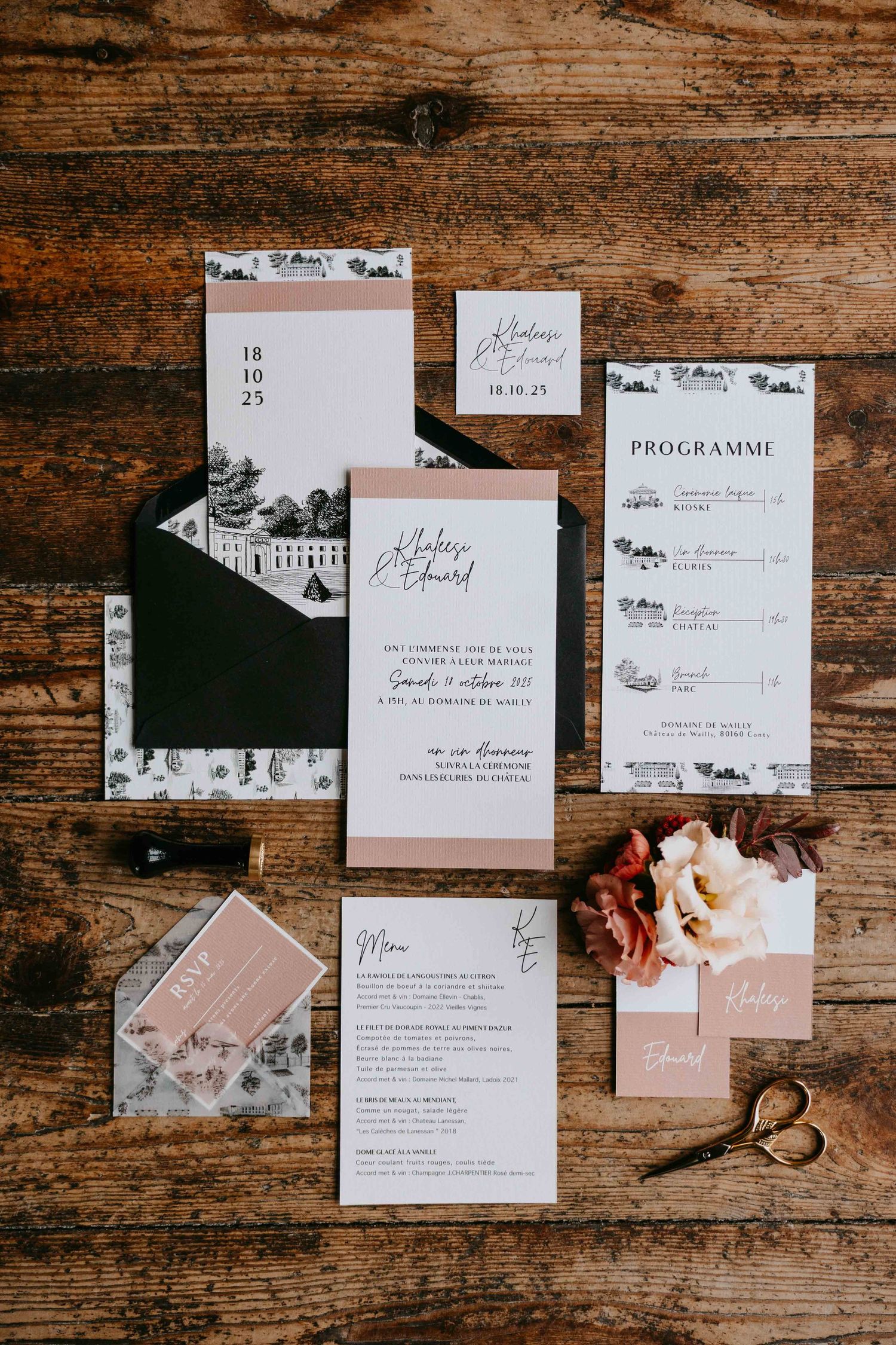 Elegant wedding stationery suite with blush pink and black invitations, menu, and programme cards on rustic wood.