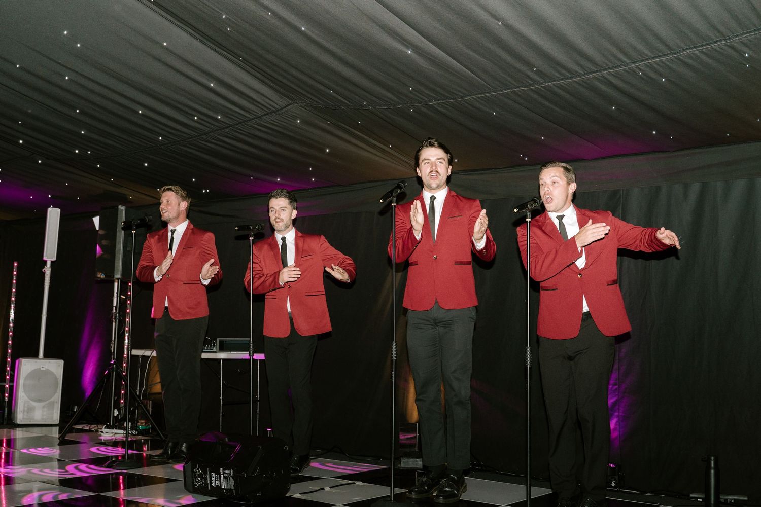The Jersey Boys perform on stage at an elegant wedding venue