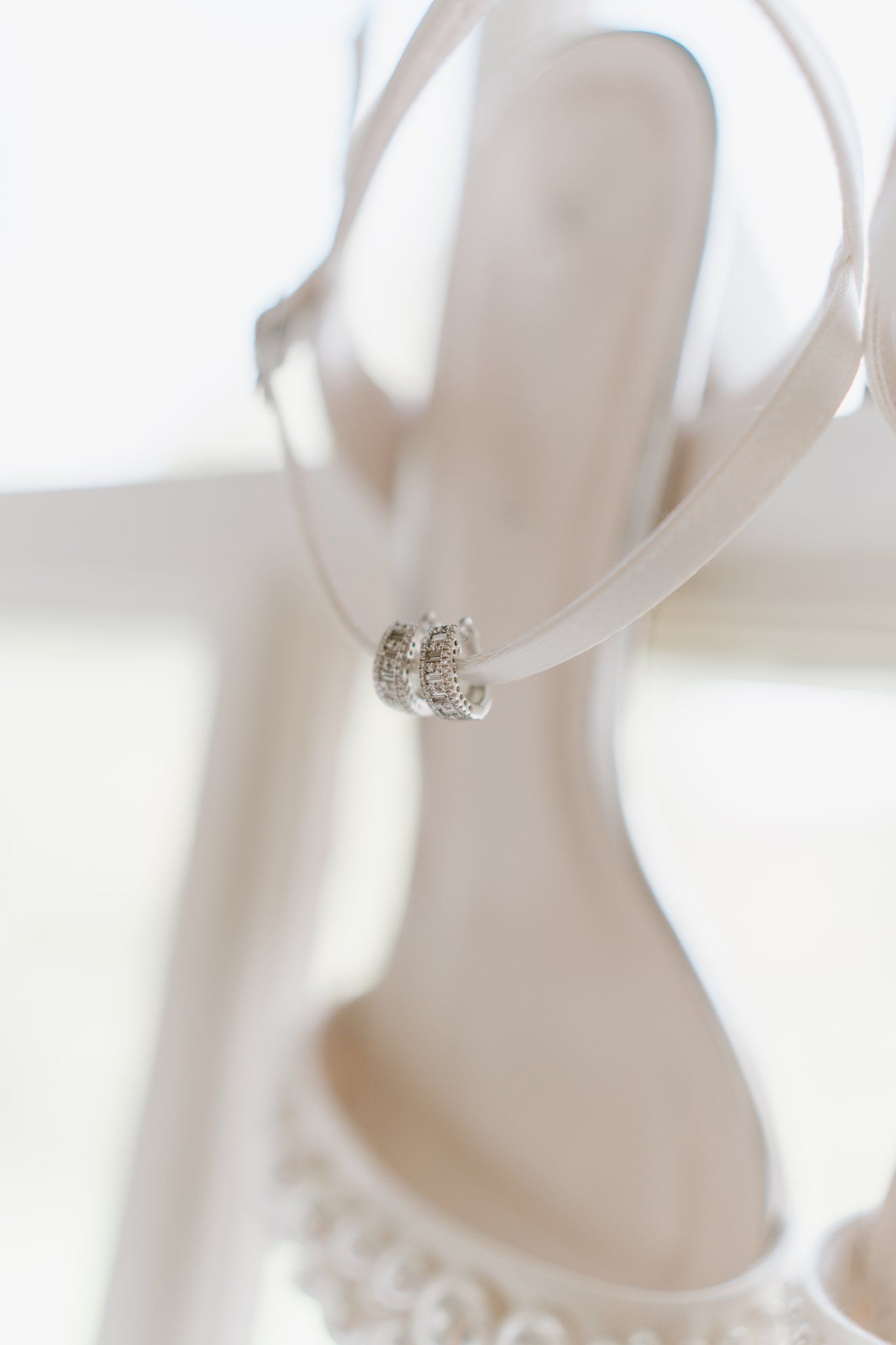 Elegant white bridal heels with delicate lace detailing and crystal rhinestone ankle strap buckle closure.