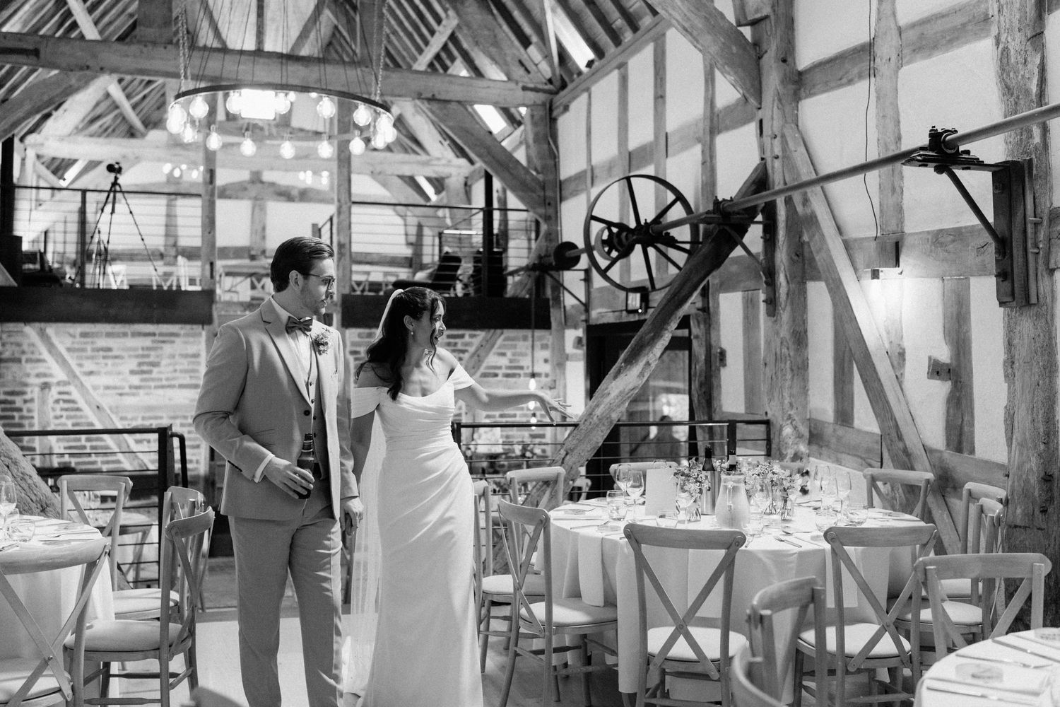 Bride and groom share a moment in a rustic barn wedding venue, black and white photo.