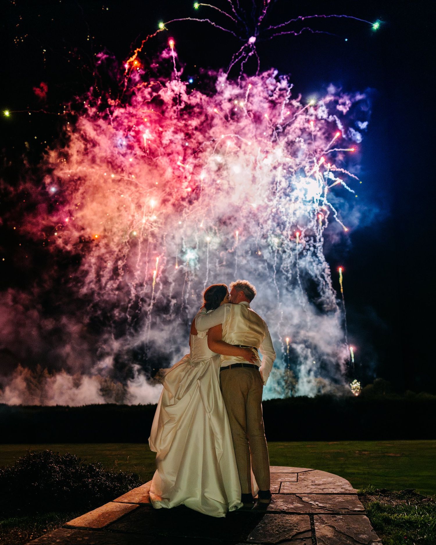 Bride and groom watching fireworks over the lawn at Brinsop Court, Herefordshire