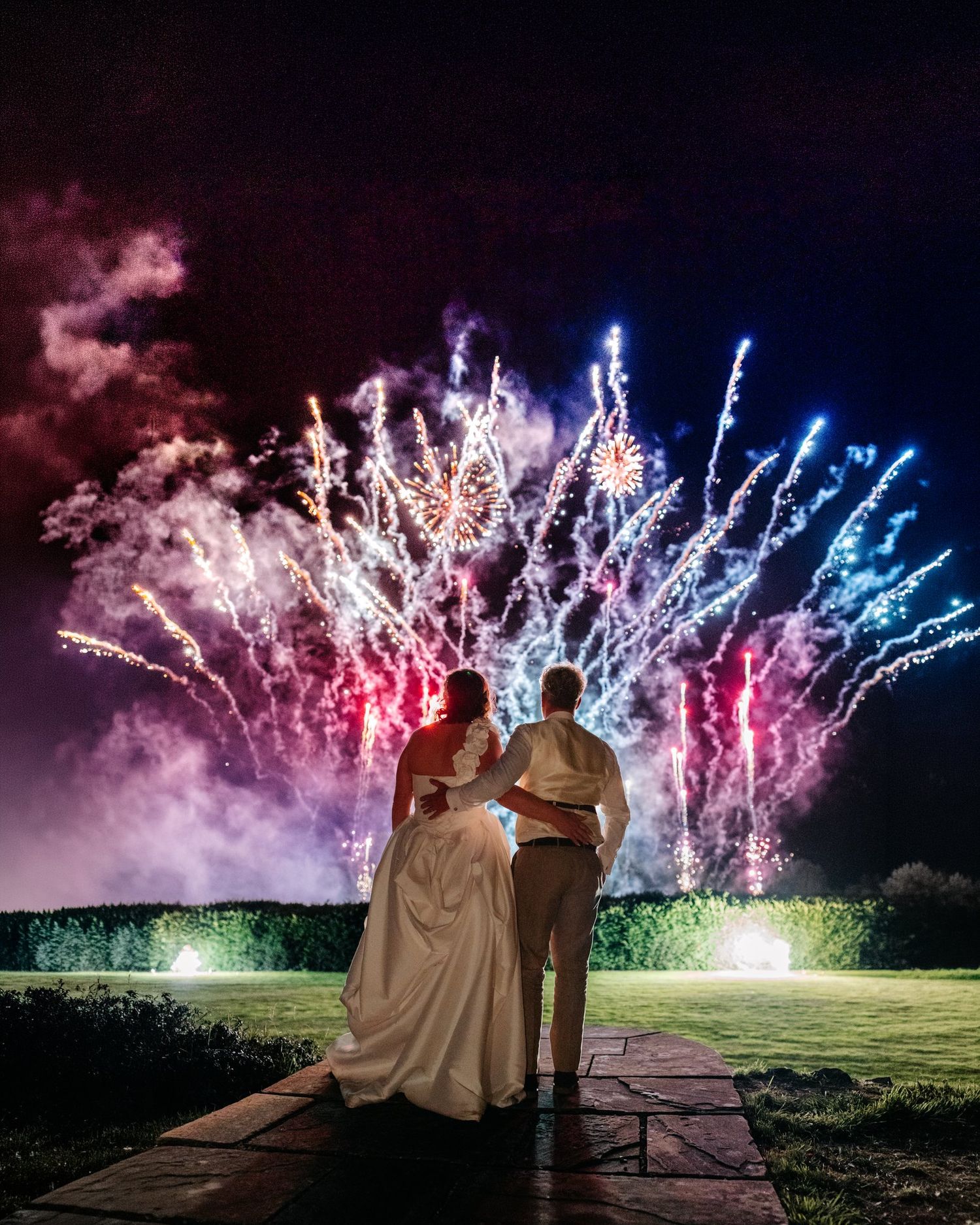 Bride and groom watching fireworks over the lawn at Brinsop Court, Herefordshire