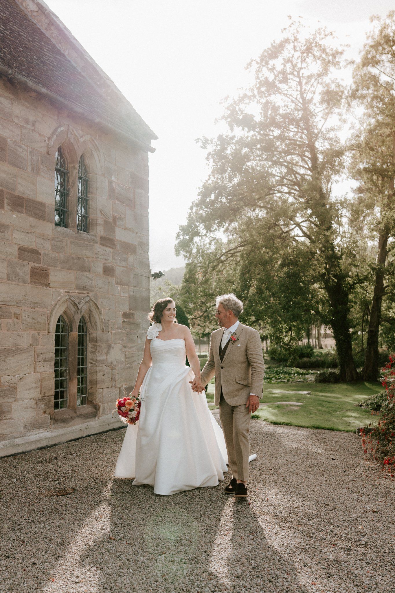 Bride and groom laughing together in the courtyard at Brinsop Court