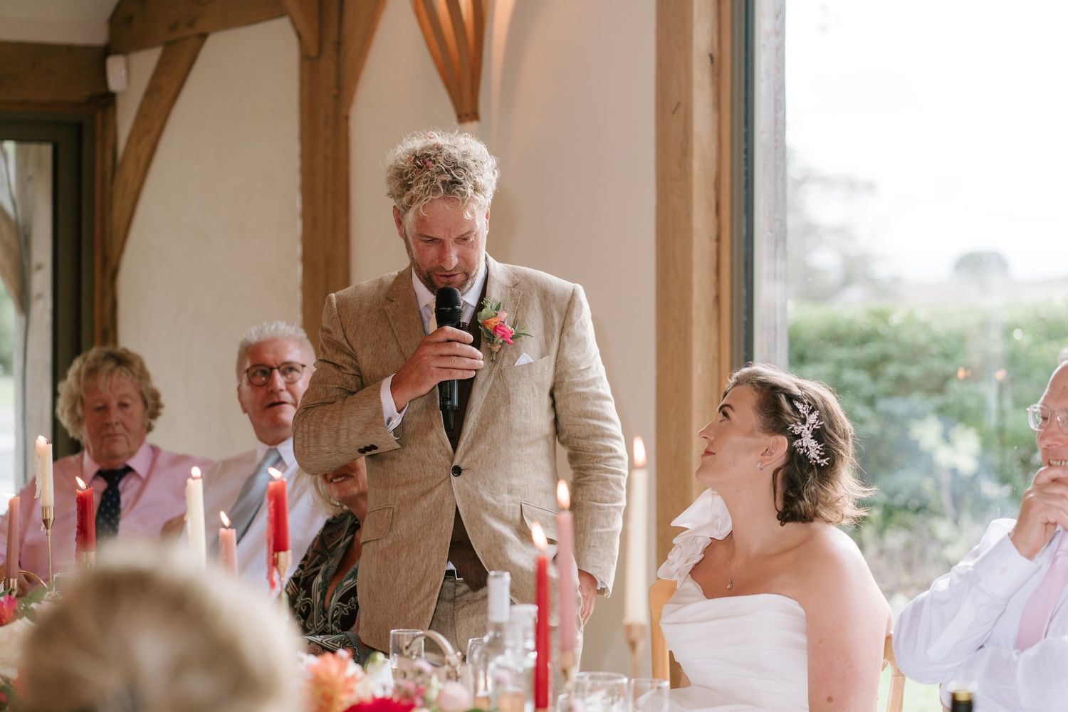 Groom giving his speech as the bride looks up at him in the Knot Barn Brinsop Court