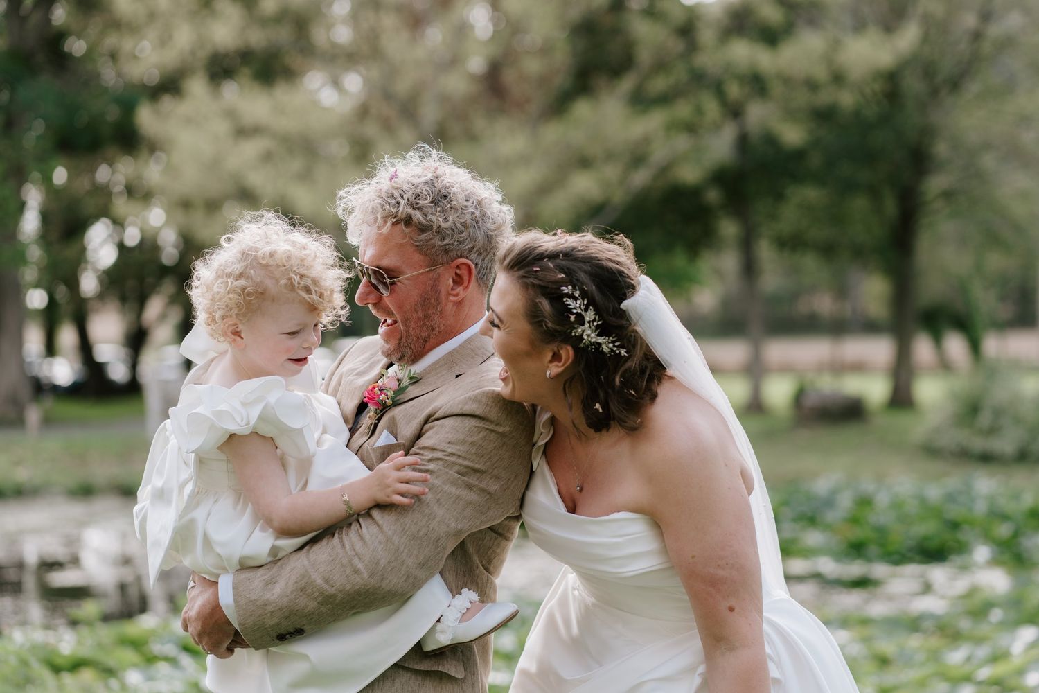 Bride and groom with their daughter by the lily pond at Brinsop Court