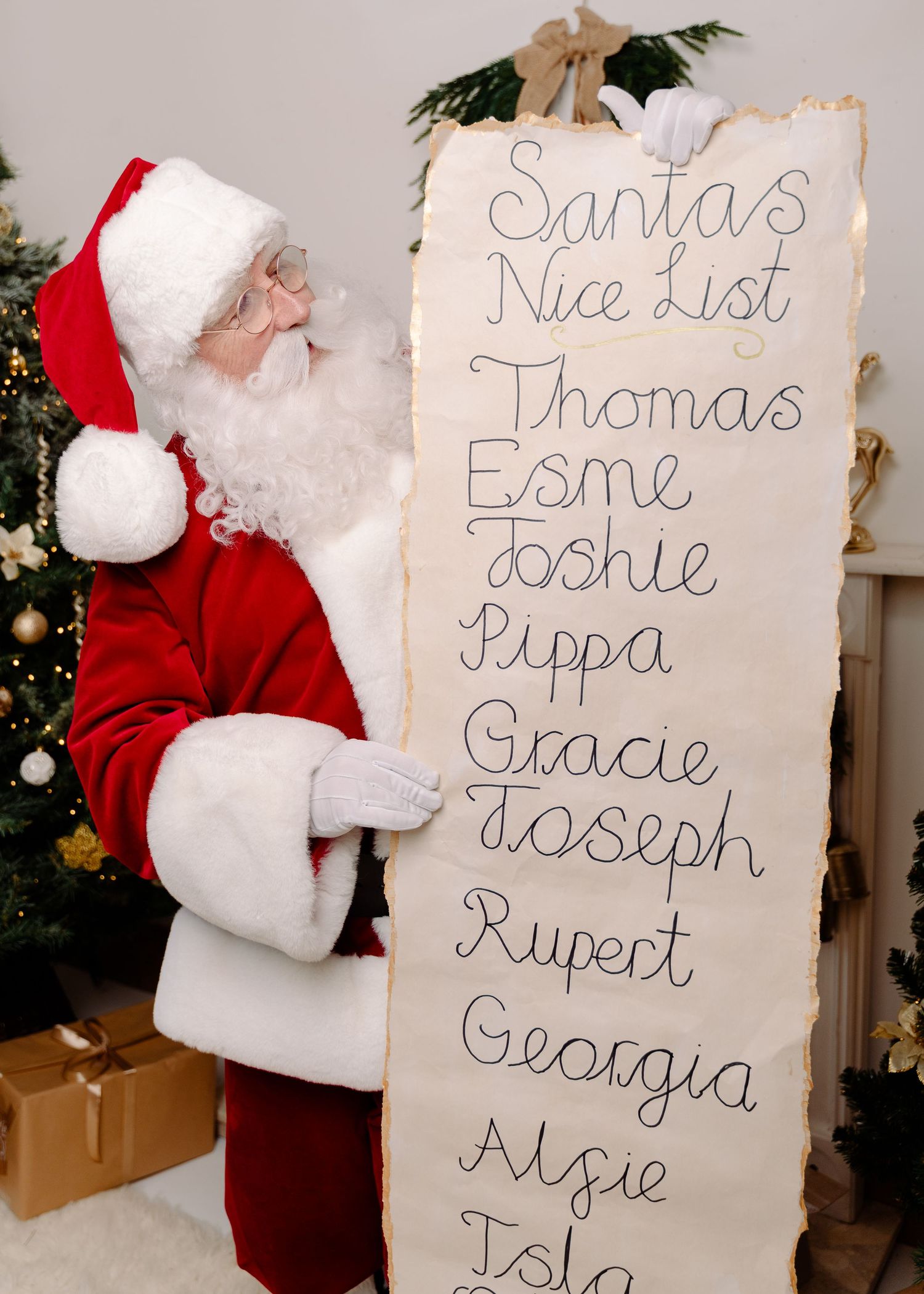 Santa Claus holds a large scroll displaying his Nice List with children's names including Thomas, Esme, and Gracie.