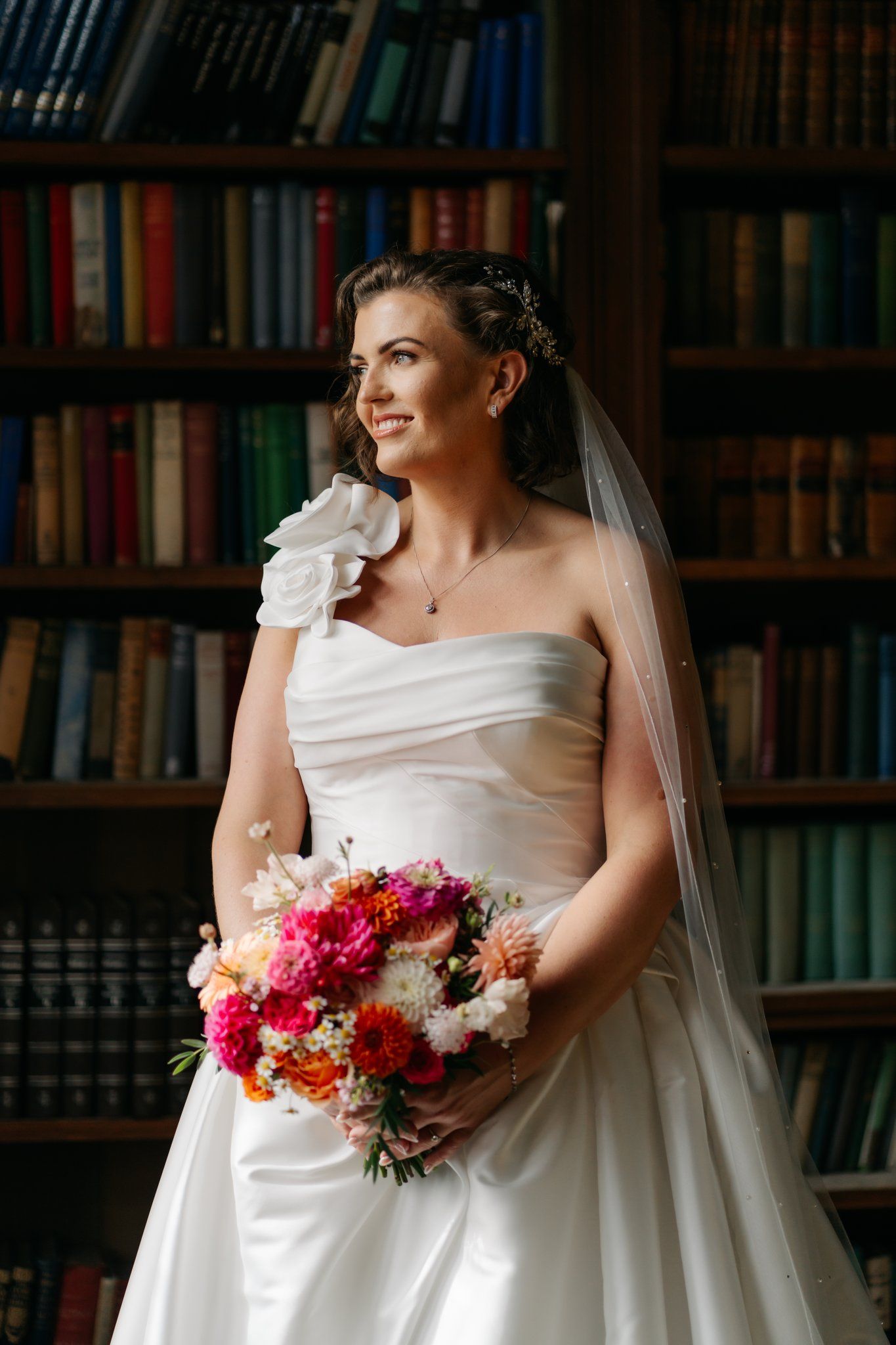 Natural bridal portrait in front of the bookshelves in the Brinsop Court library
