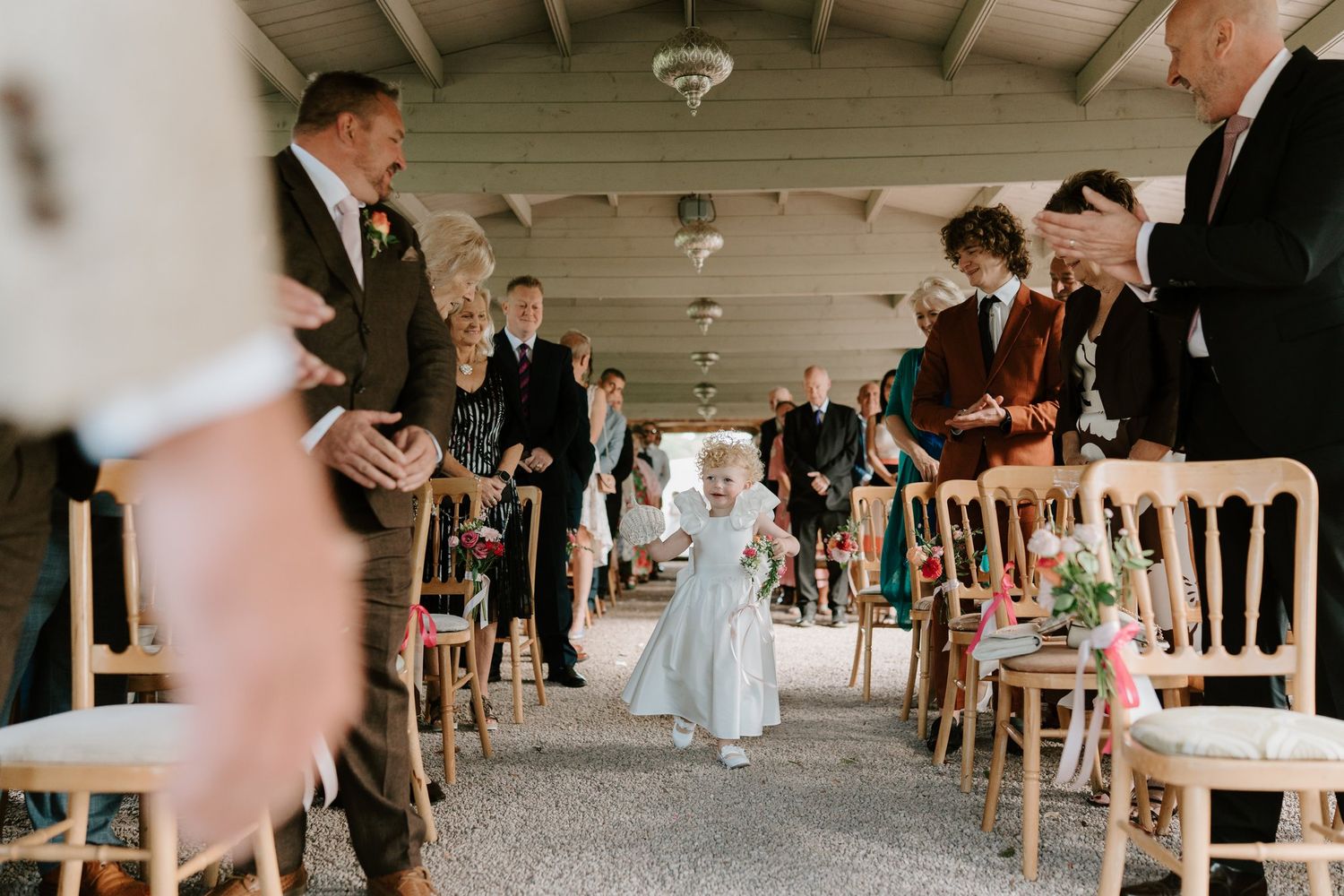 Flower girl walking down the aisle in the Astley Pergola at Brinsop Court