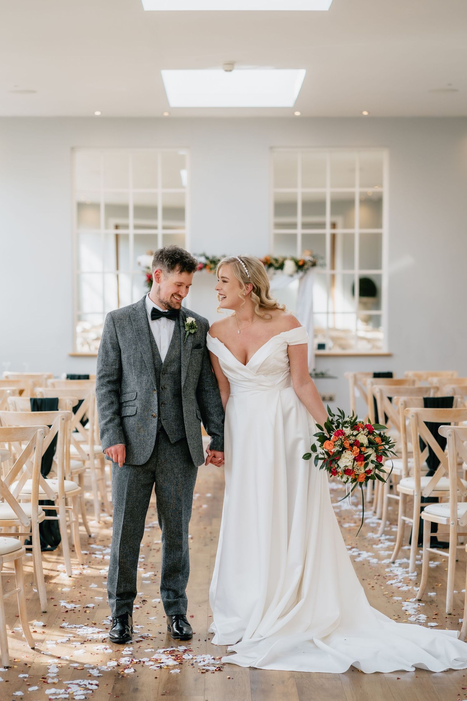 Worcestershire Bride and groom at Bredenbury court barns holding hands and smiling at each other in an elegant wedding ceremony room