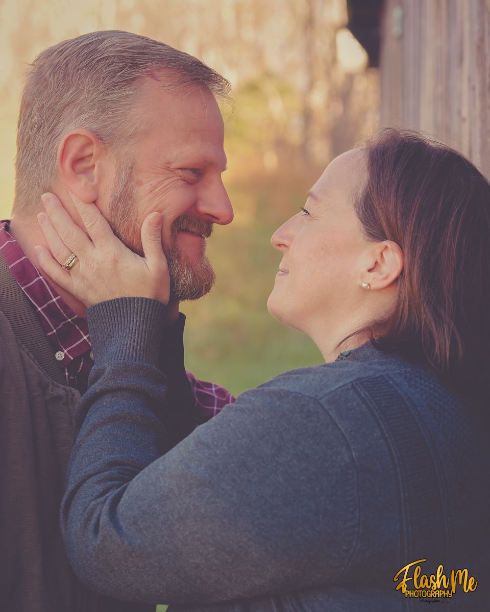 Happy couple sharing a romantic moment outdoors, smiling at each other in warm golden light.