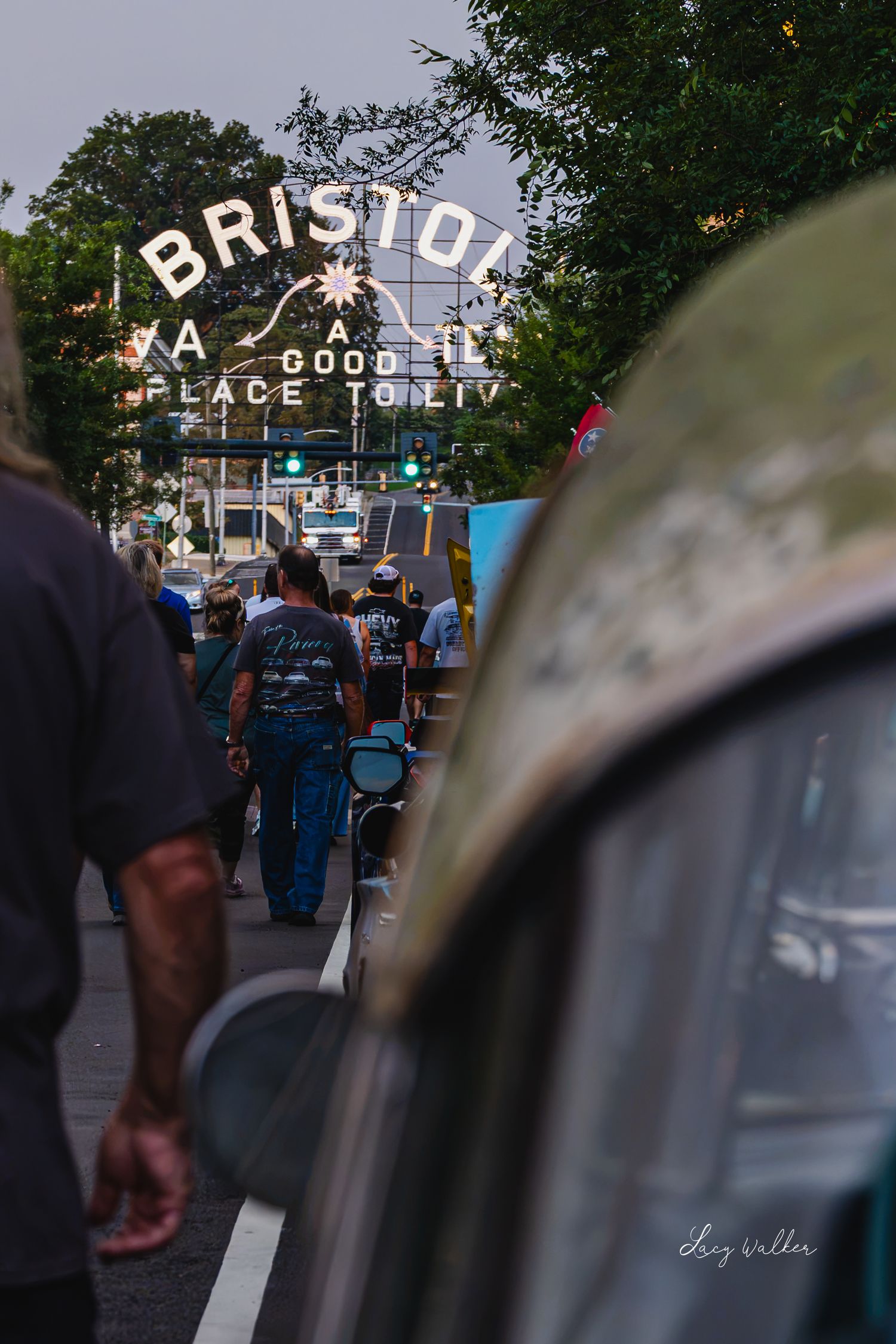 People walking toward the iconic Bristol VA sign reading A Good Place To Live during a lively street event.
