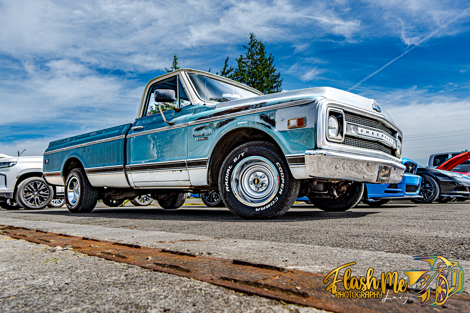 Vintage light blue Chevrolet pickup truck with patina finish parked at an outdoor classic car show.