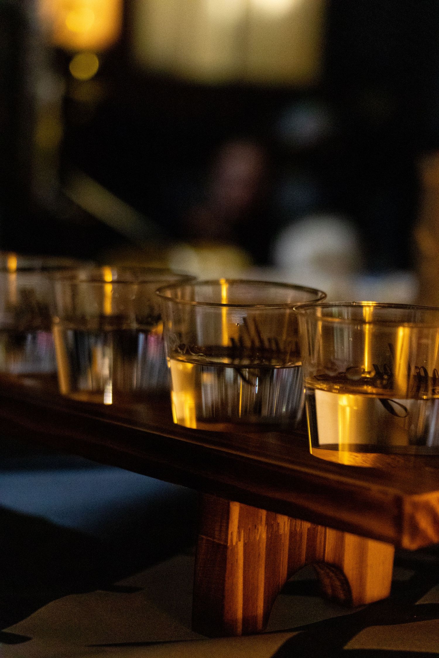 Warm bar interior at night with glassware lined up along the counter