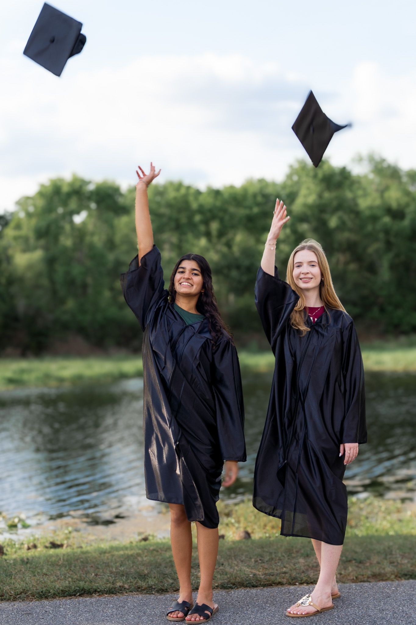 Graduation students celebrating tossing caps during a senior photo session in Orlando Florida. By Aperture Haus Photography