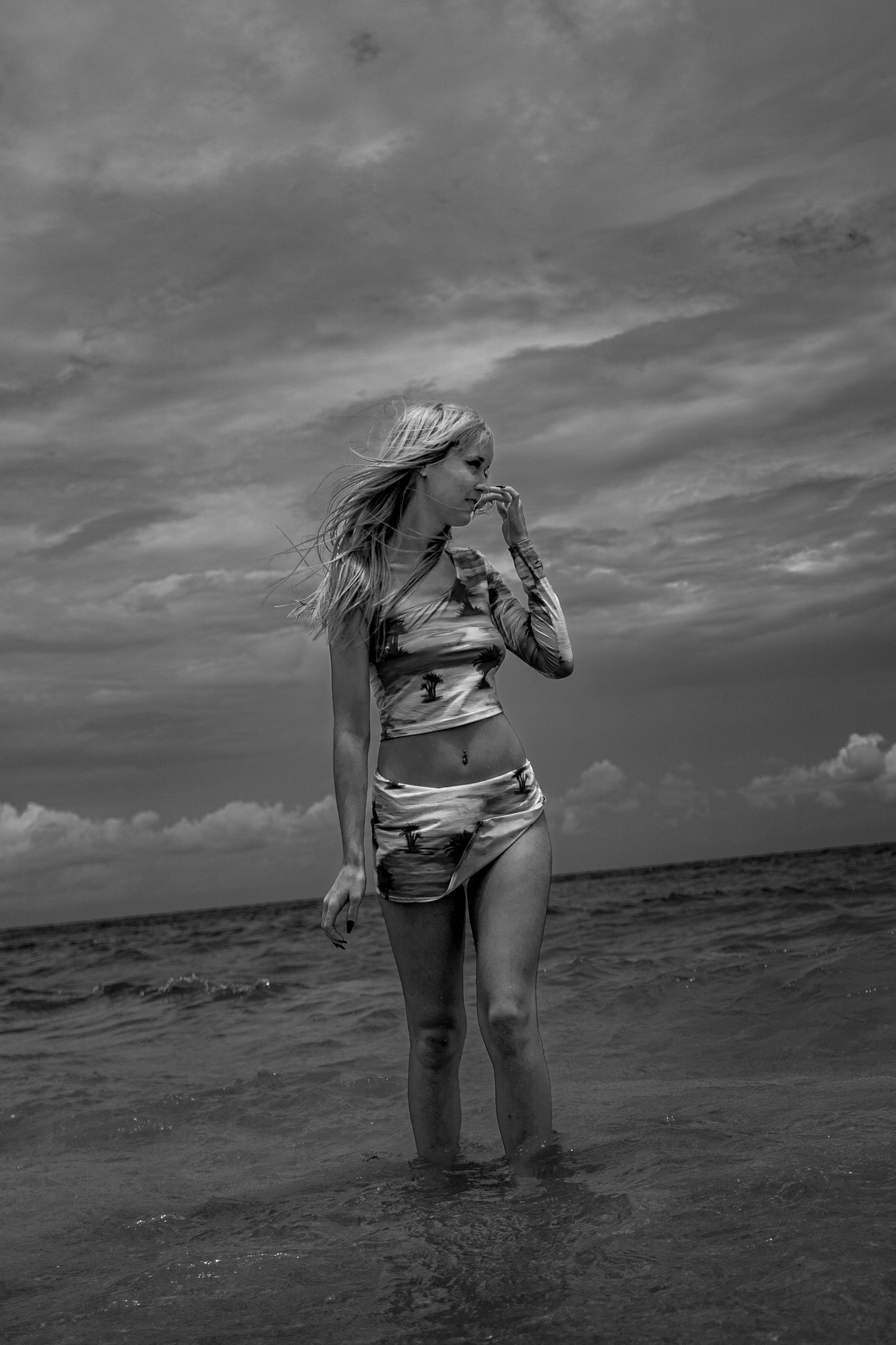 Black and White beach portrait. Woman walking along shoreline in Miami, Florida.