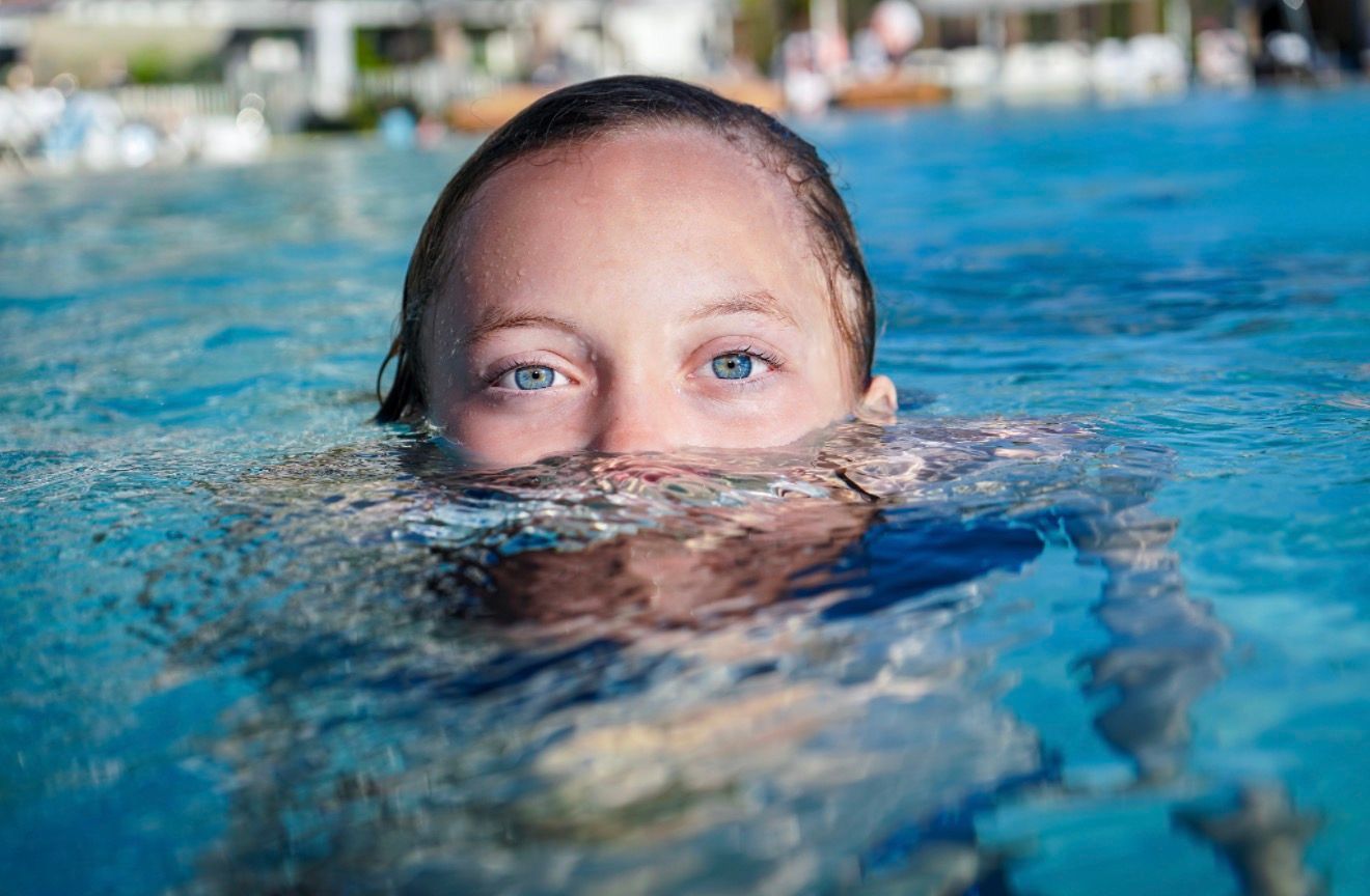 Portrait of Blue eyed girl submerged halfway  in water