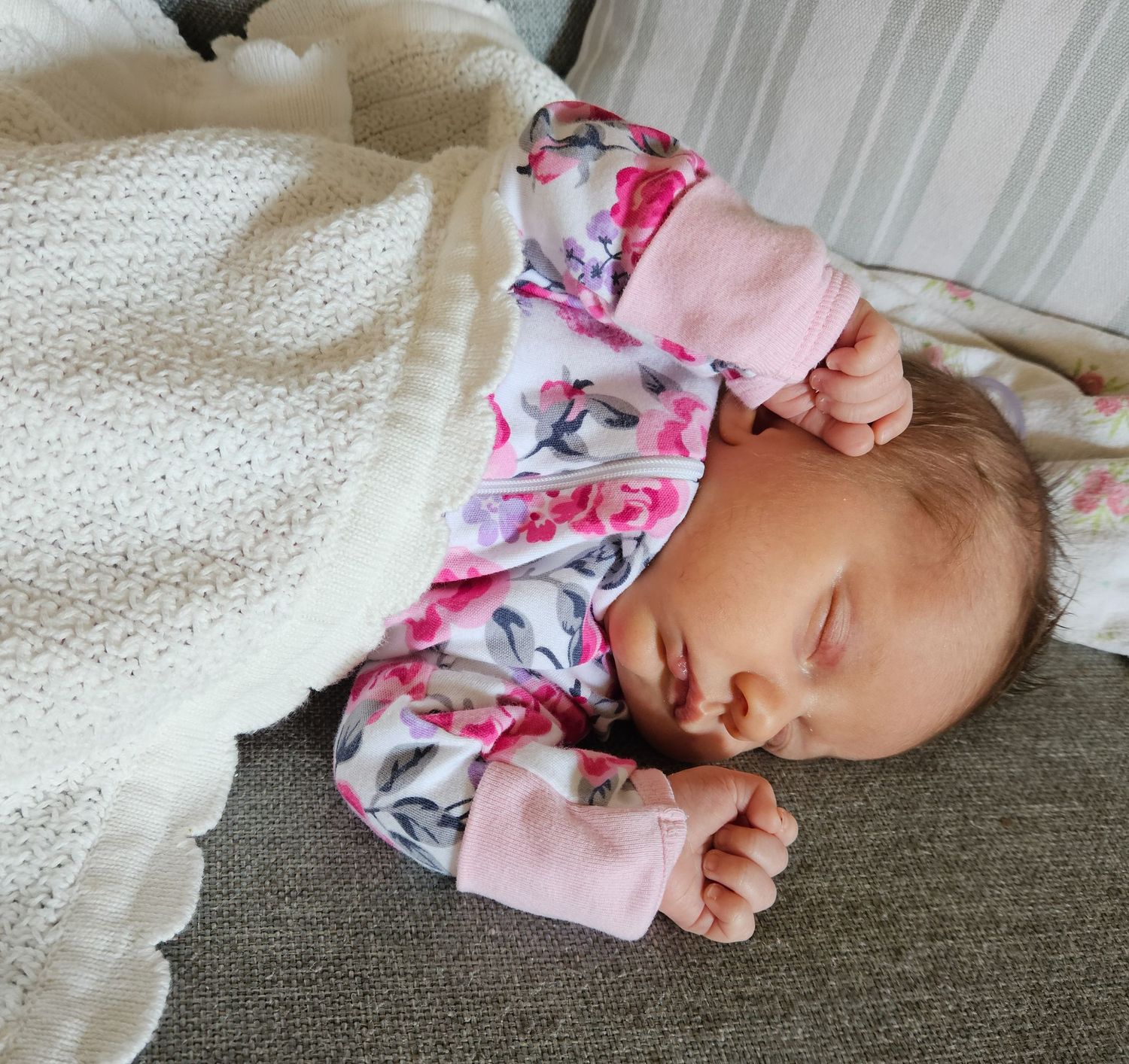 Sleeping newborn baby wrapped in a soft blanket, photographed indoors with natural light
