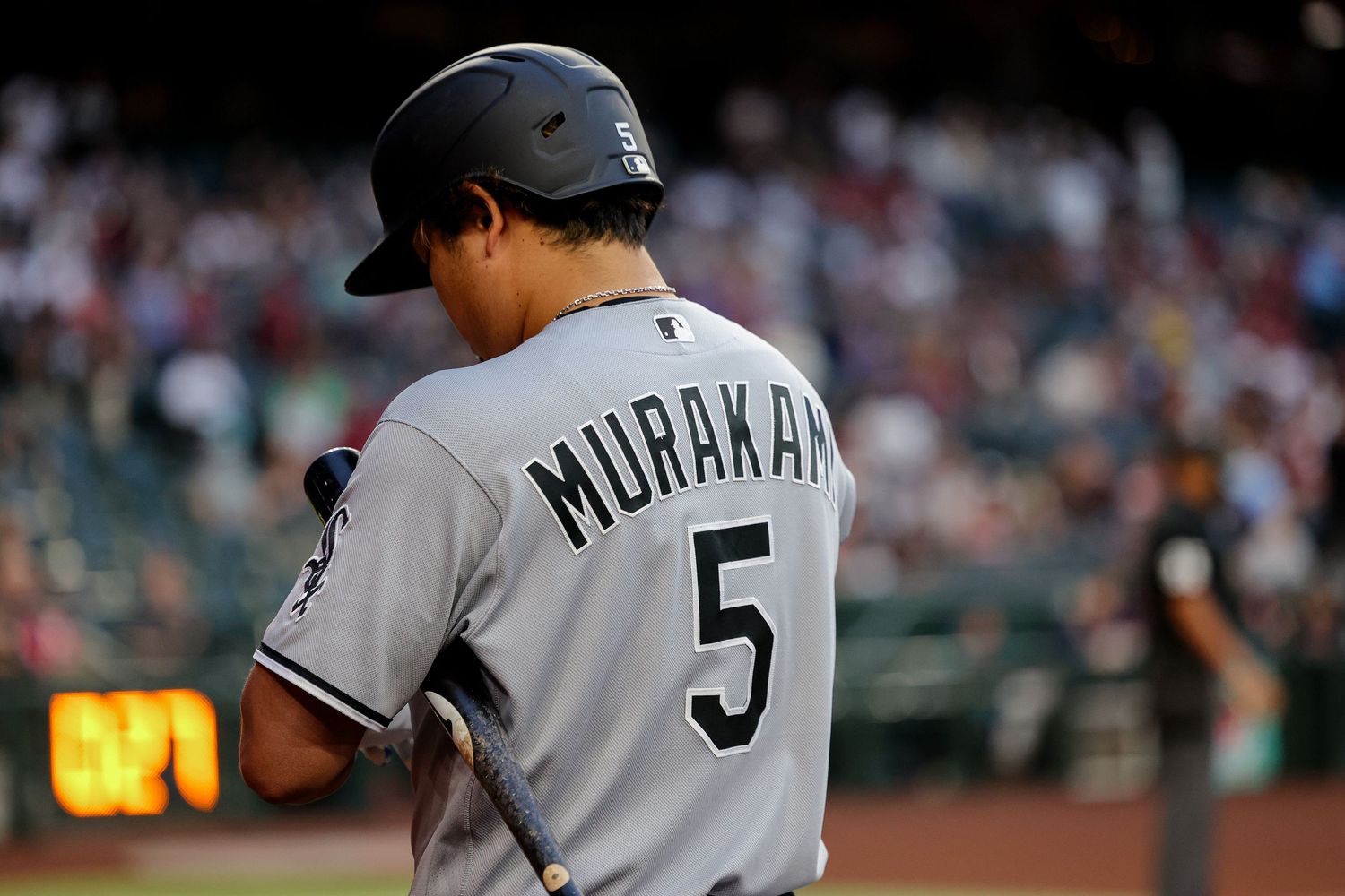 Baseball player wearing Murakami number 5 white jersey stands on field during professional MLB game.