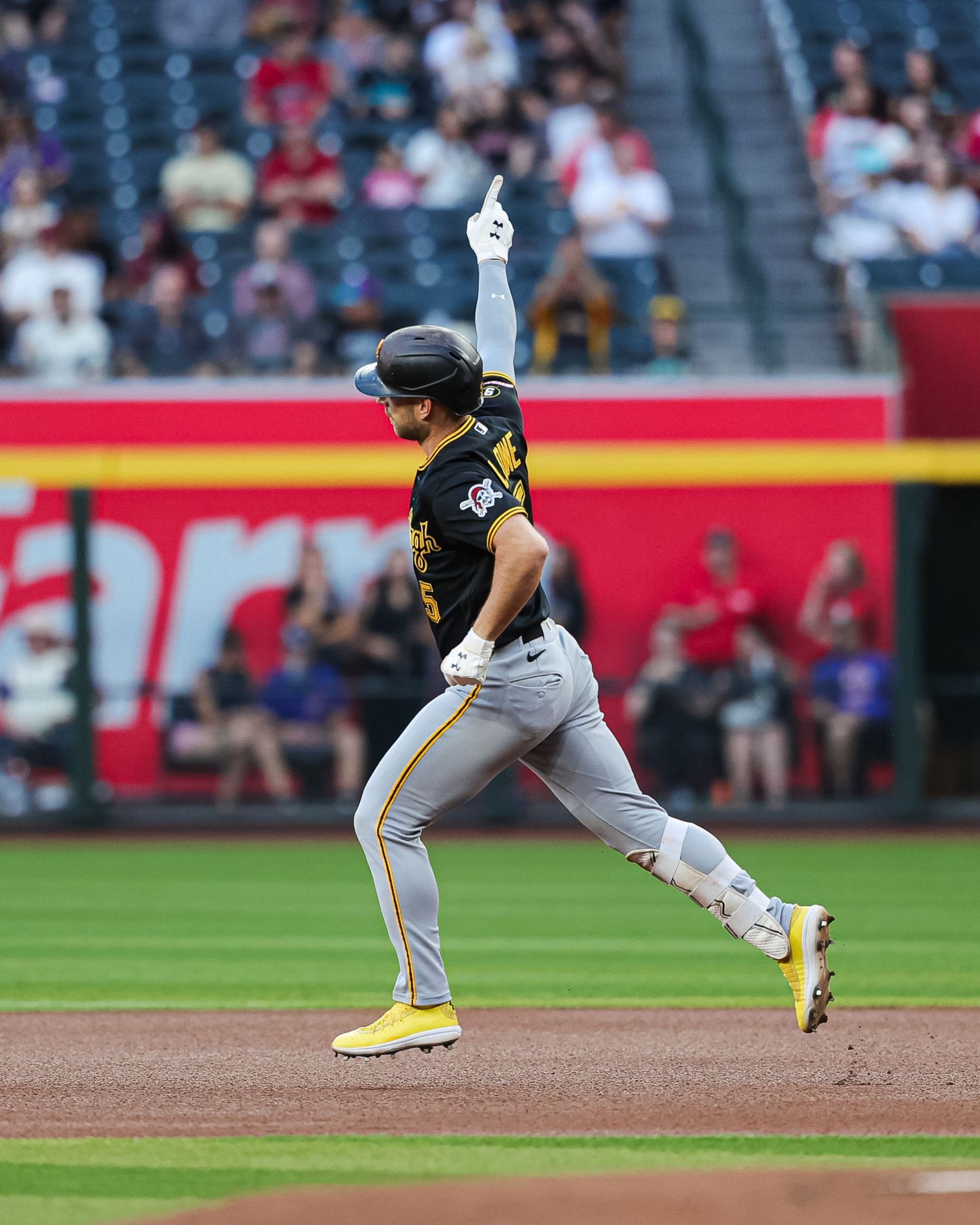 Pittsburgh Pirates player rounds the bases with arm raised after hitting a home run.