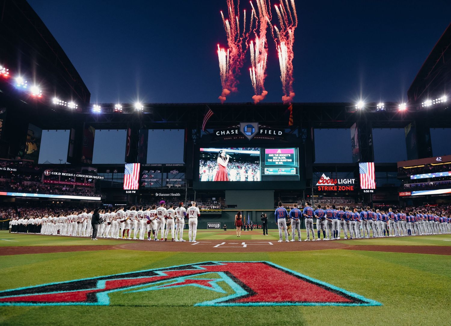 Fireworks light up Chase Field stadium during a pregame ceremony with both teams lined up.
