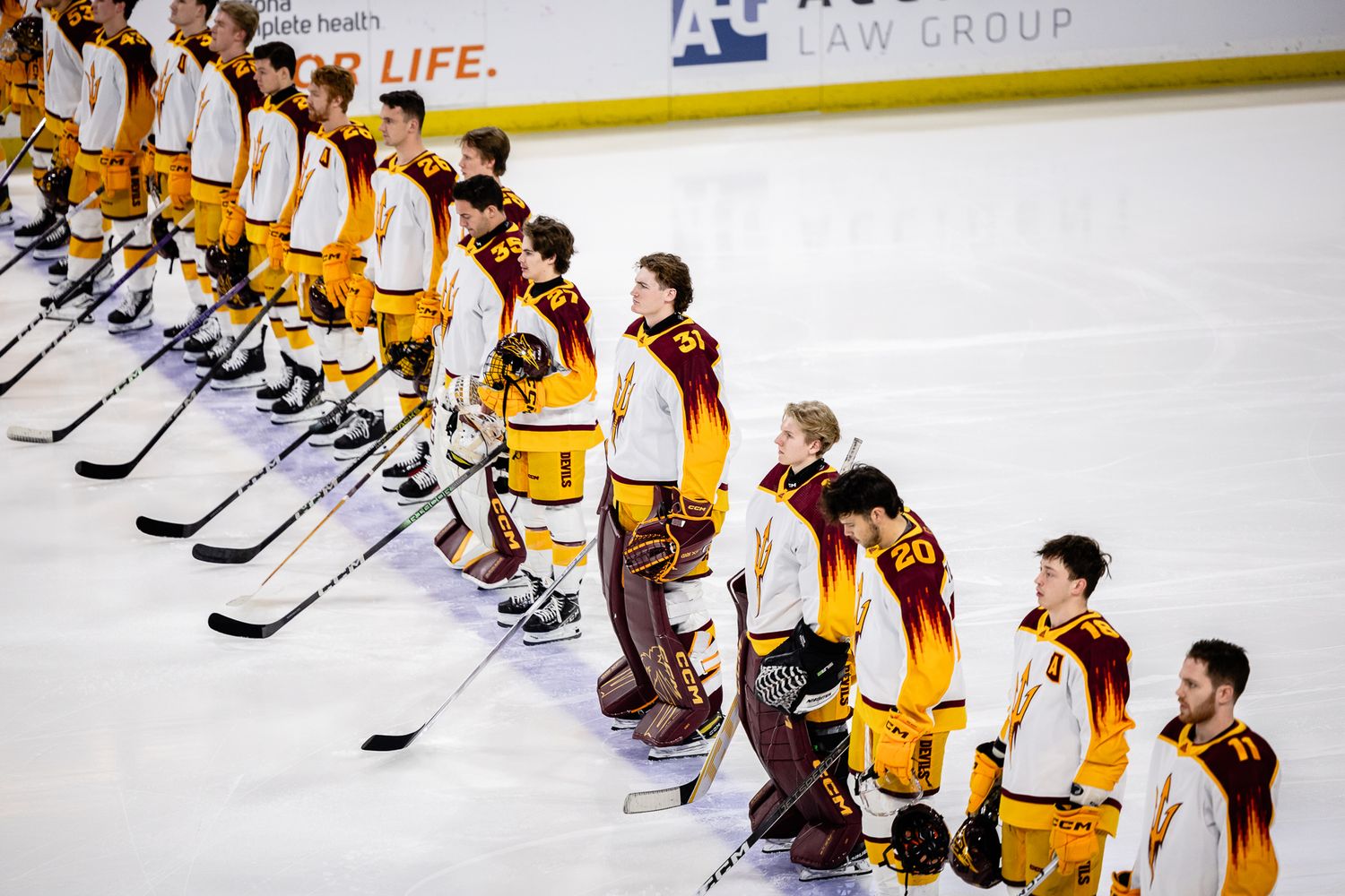 Arizona State Sun Devils hockey team lines up on the ice during the national anthem before a game.
