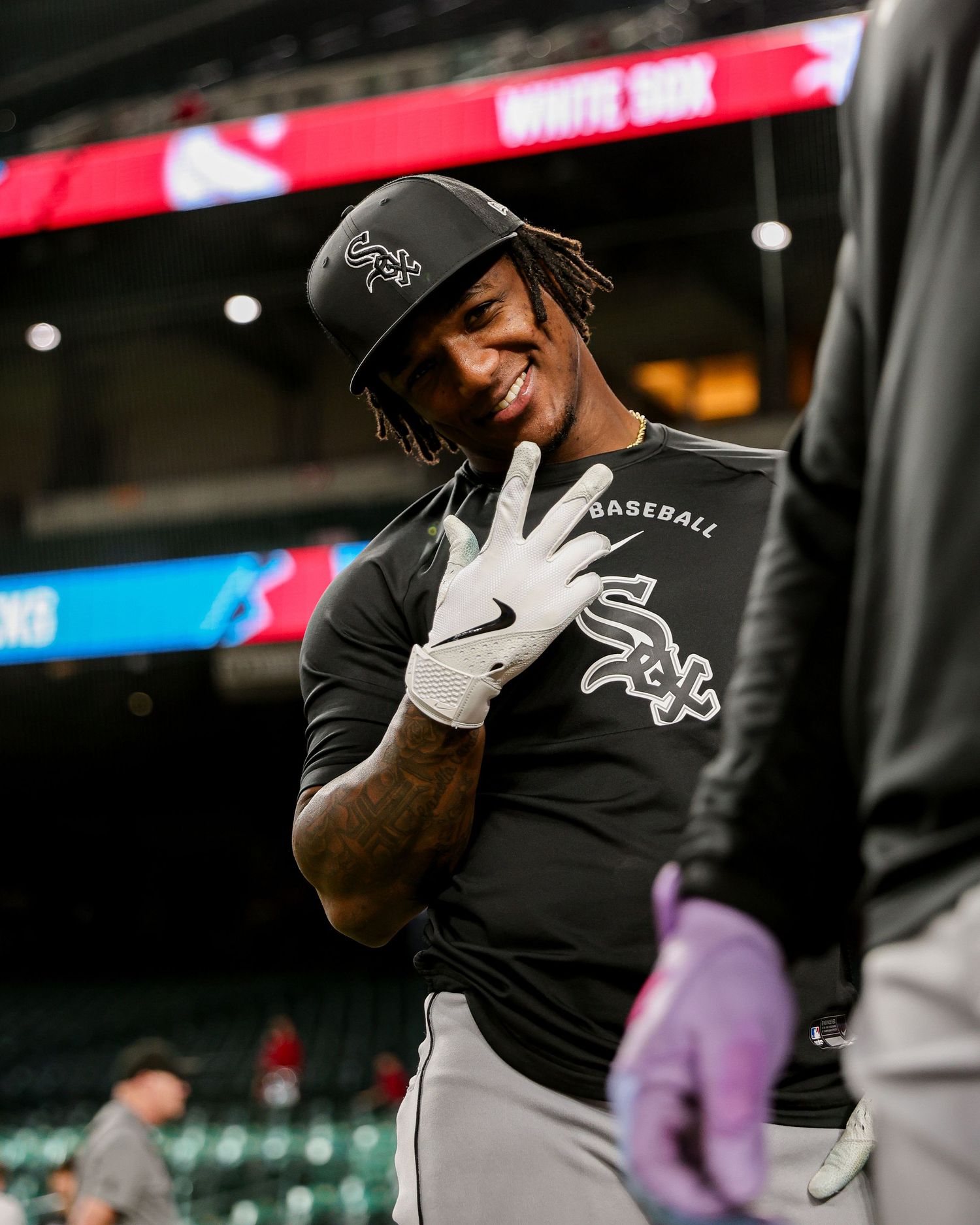 Chicago White Sox player smiles and holds up fingers in the dugout before a game.
