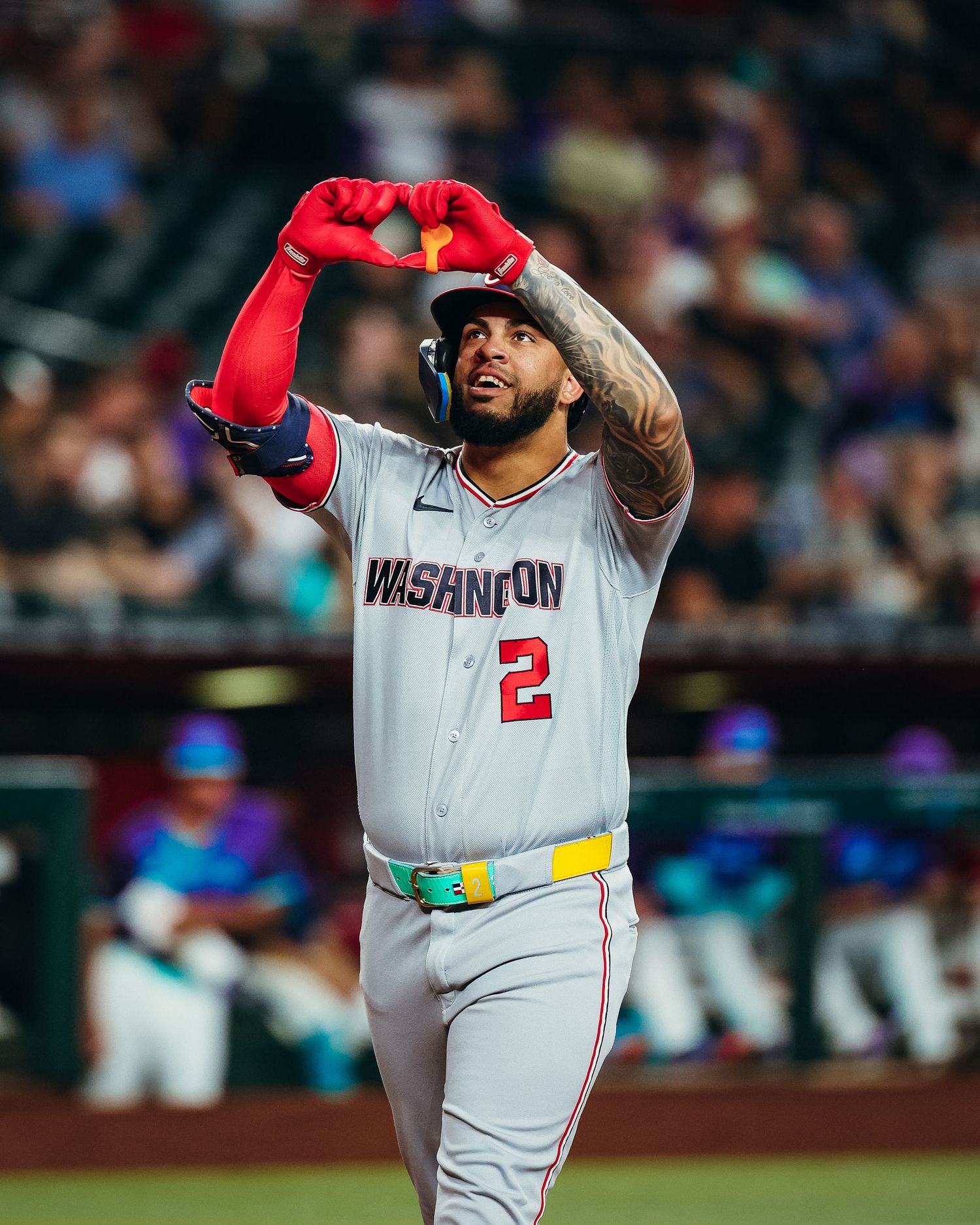 Washington Nationals player #2 makes heart gesture after hitting home run during MLB game.