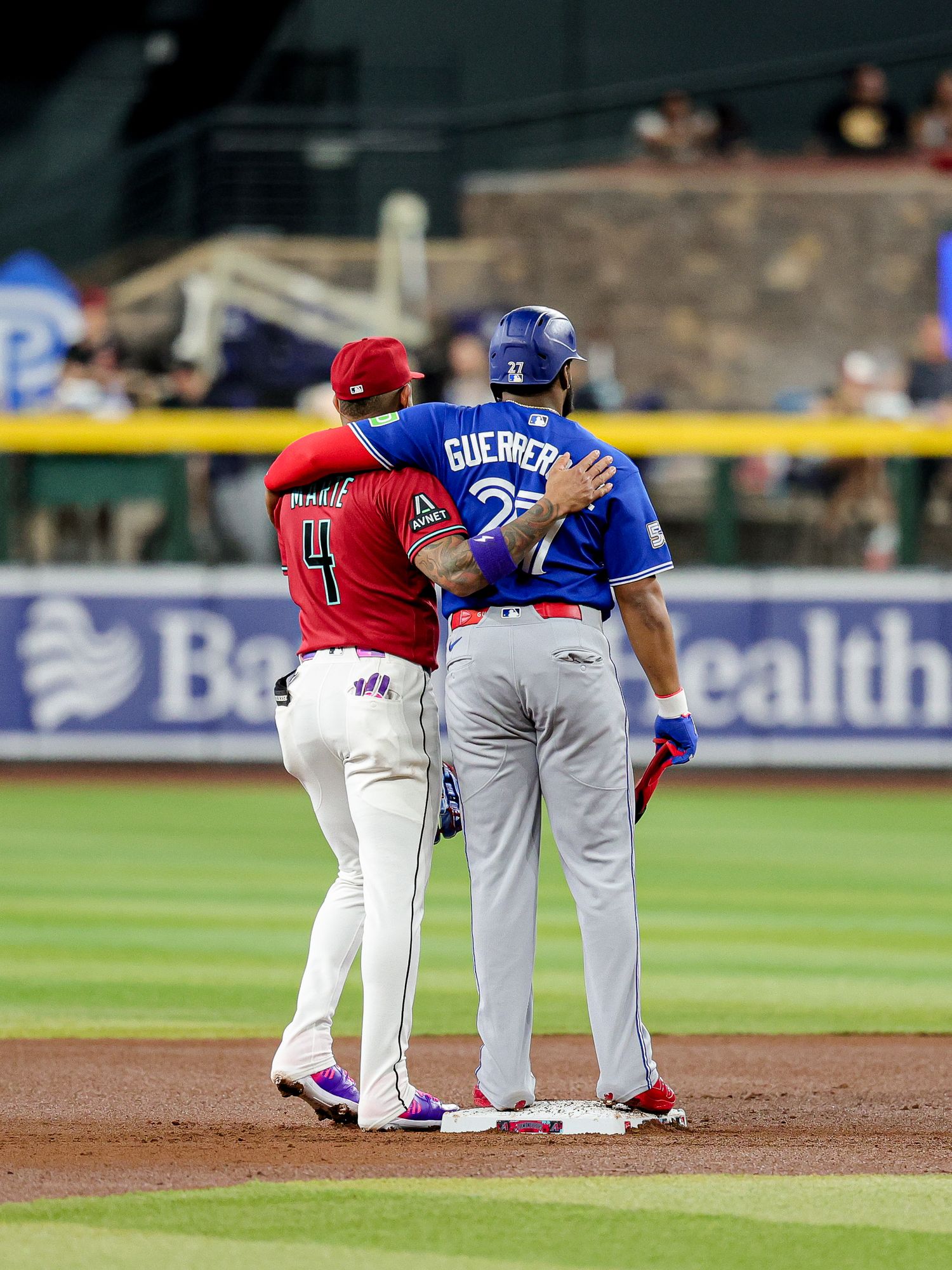 Arizona Diamondbacks player #4 and Toronto Blue Jays Guerrero Jr. #27 stand together at second base during an MLB game.