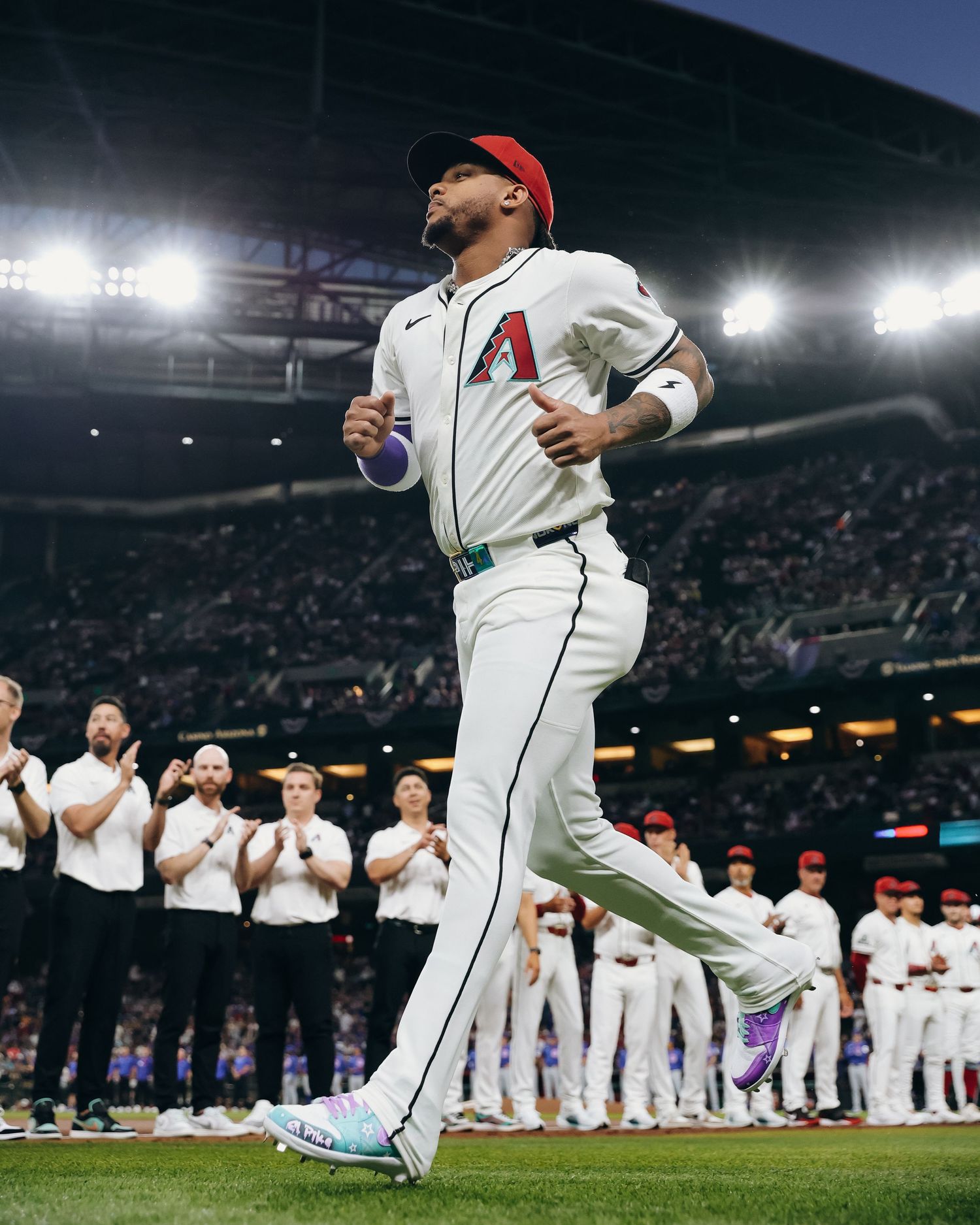 Arizona Diamondbacks player jogging onto field during pregame introductions at Chase Field baseball stadium.