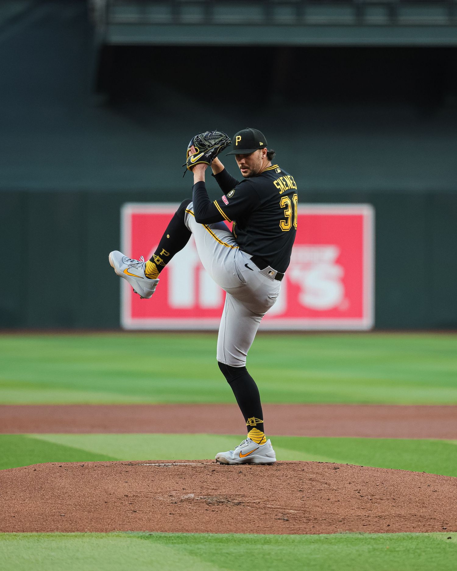 Pittsburgh Pirates pitcher delivers a pitch from the mound during an MLB game at night.