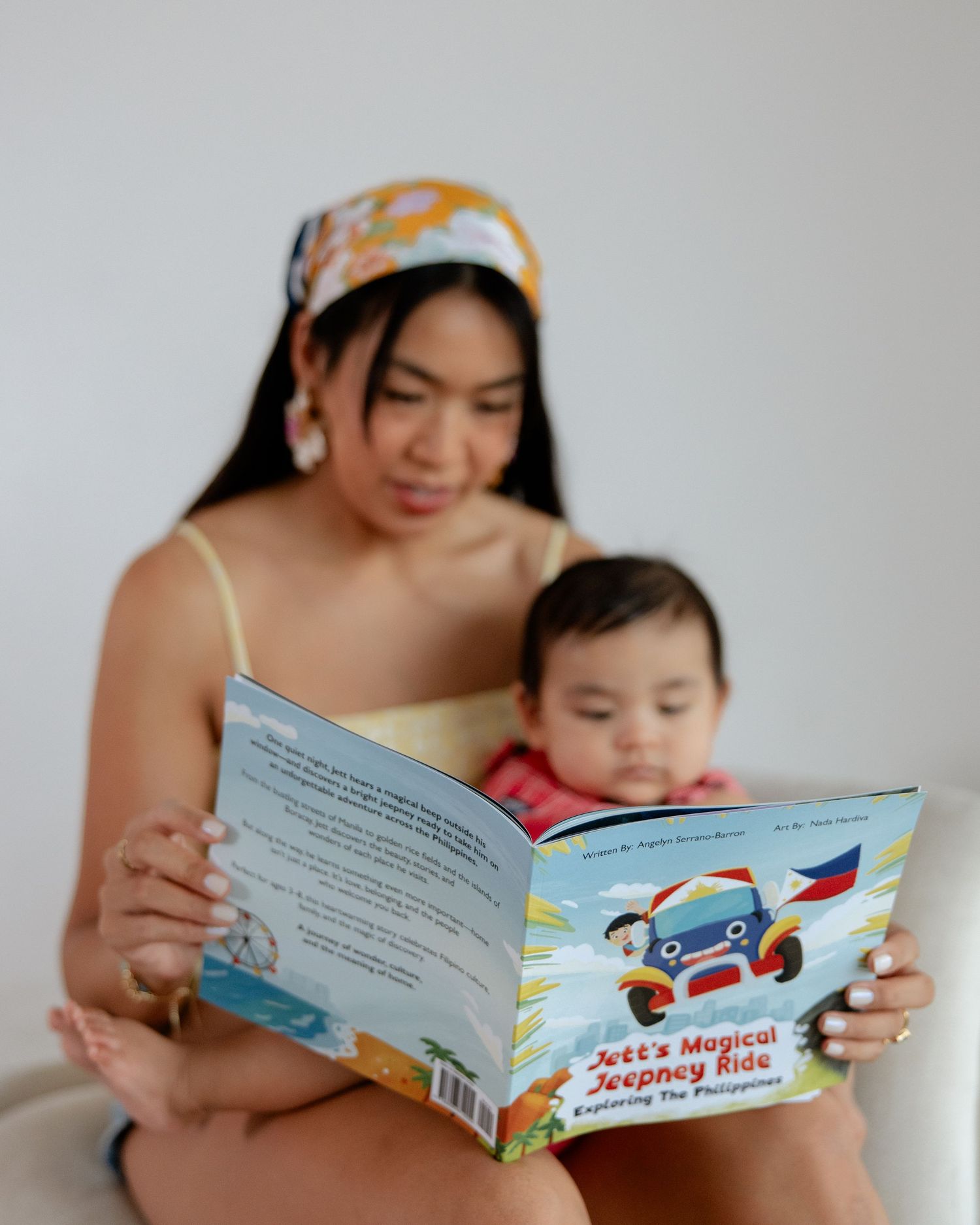 Mother and baby reading 'Jett's Magical Jeepney Ride' children's book about the Philippines together.