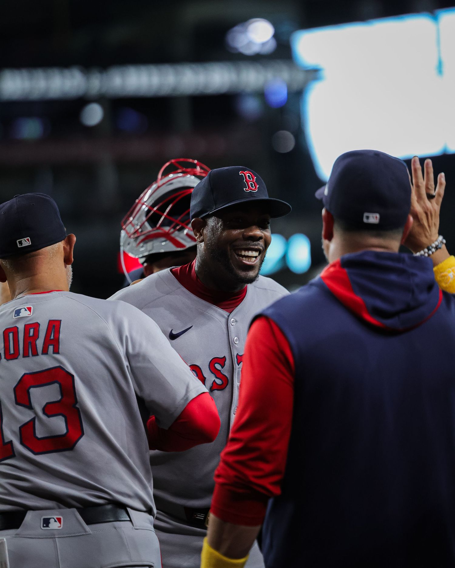 Boston Red Sox players celebrate and high-five in the dugout after a successful play.