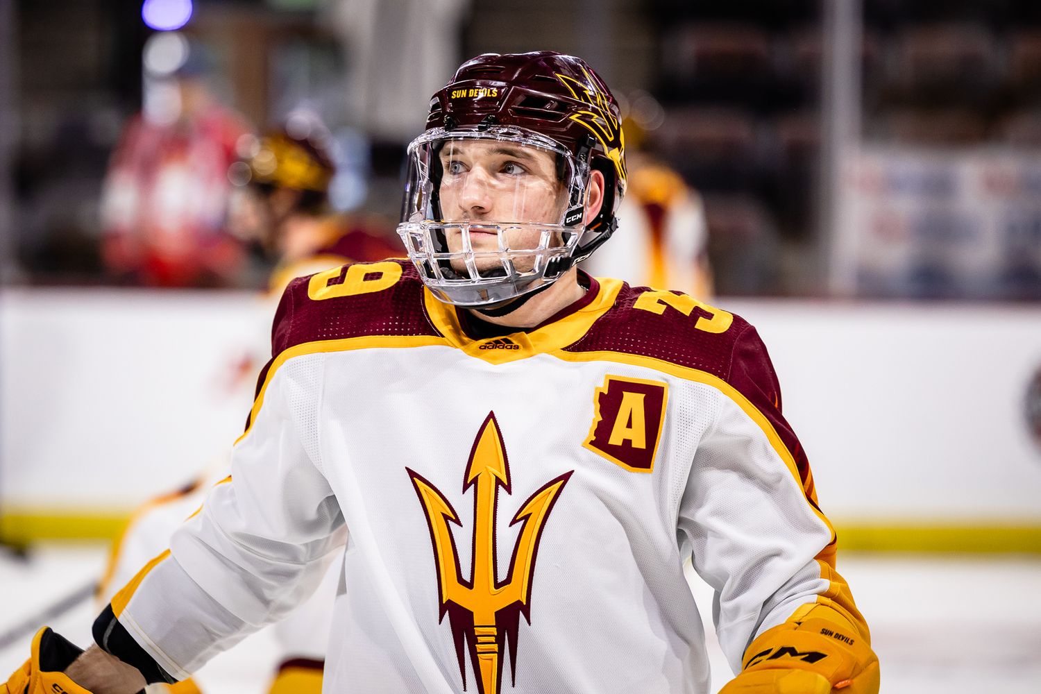 Arizona State Sun Devils hockey player wearing an alternate captain patch looks up during a game.