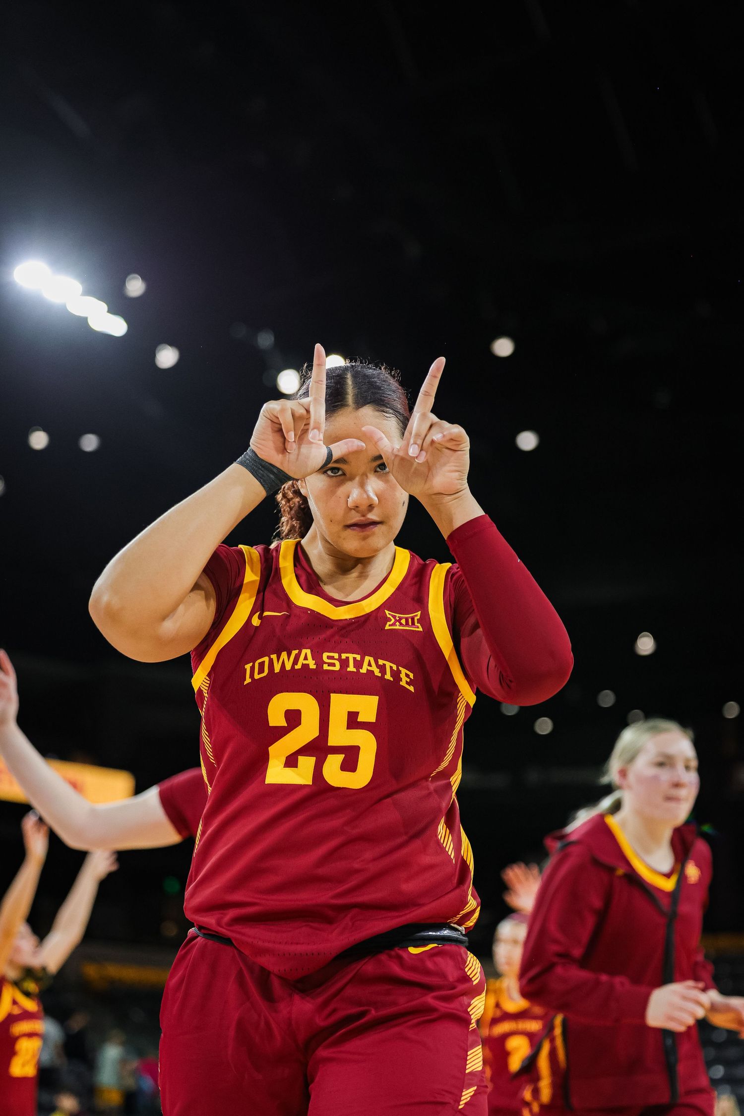 Iowa State Cyclones player #25 gestures with both hands raised during a womens college basketball game.